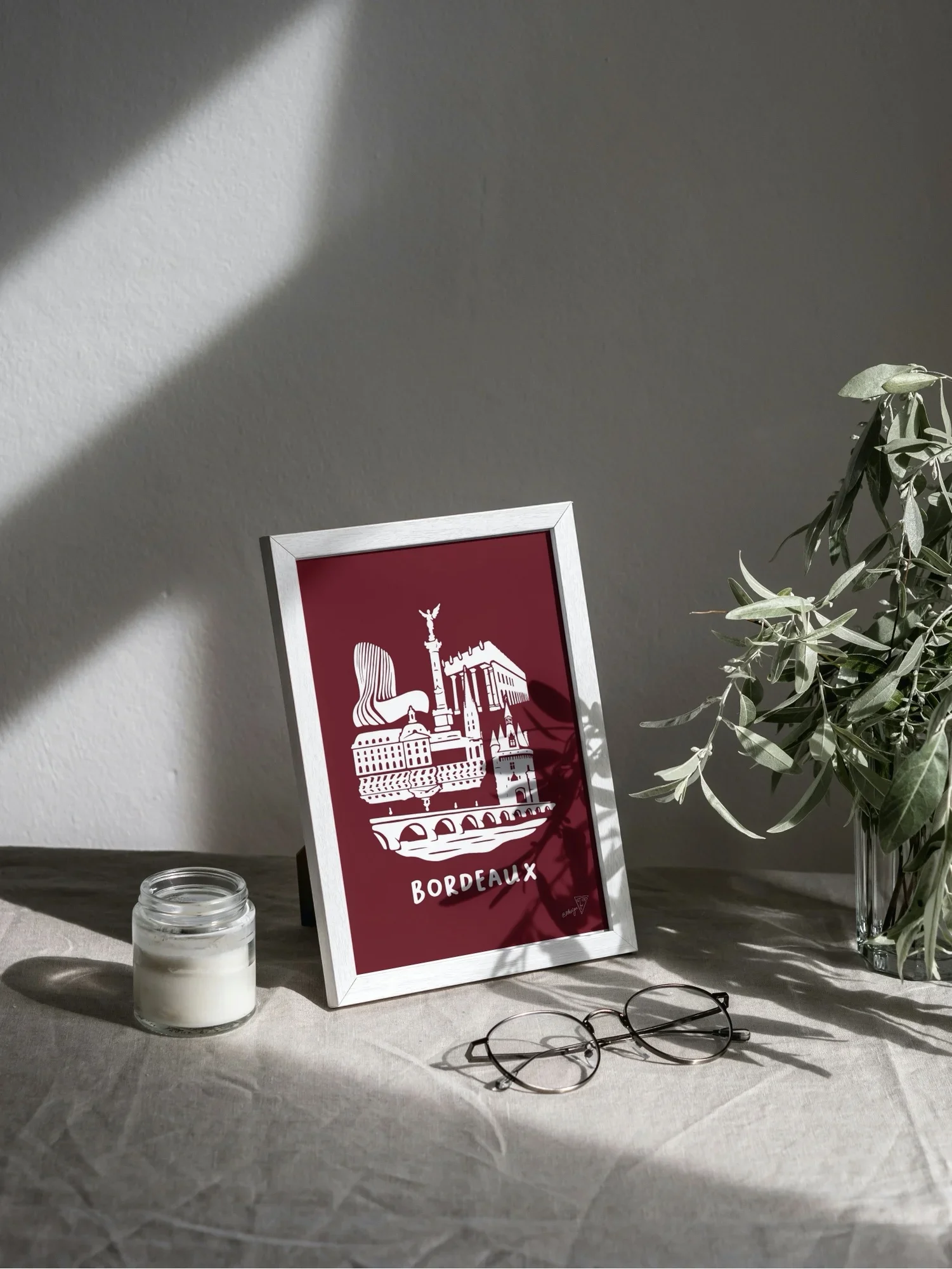 Affiche Bordeaux encadrée dans un intérieur lumineux, illustration bordeaux et blanche de la gironde