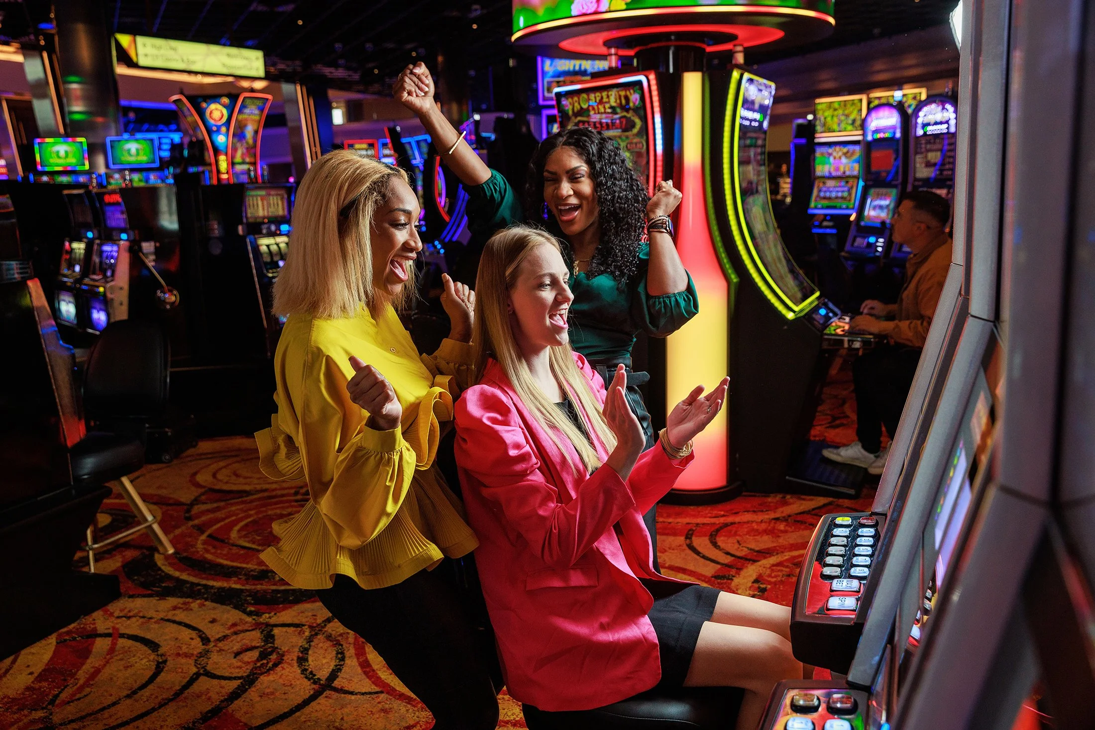Four women celebrating at a casino, enjoying slot machine gaming.