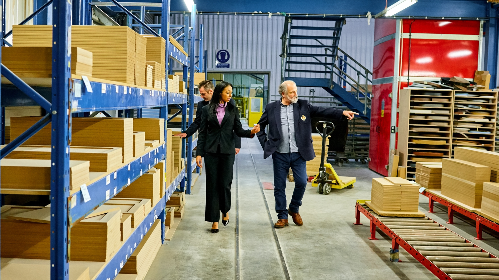 Pluma Latina Travel - 3 People Walking in a factory during a visit