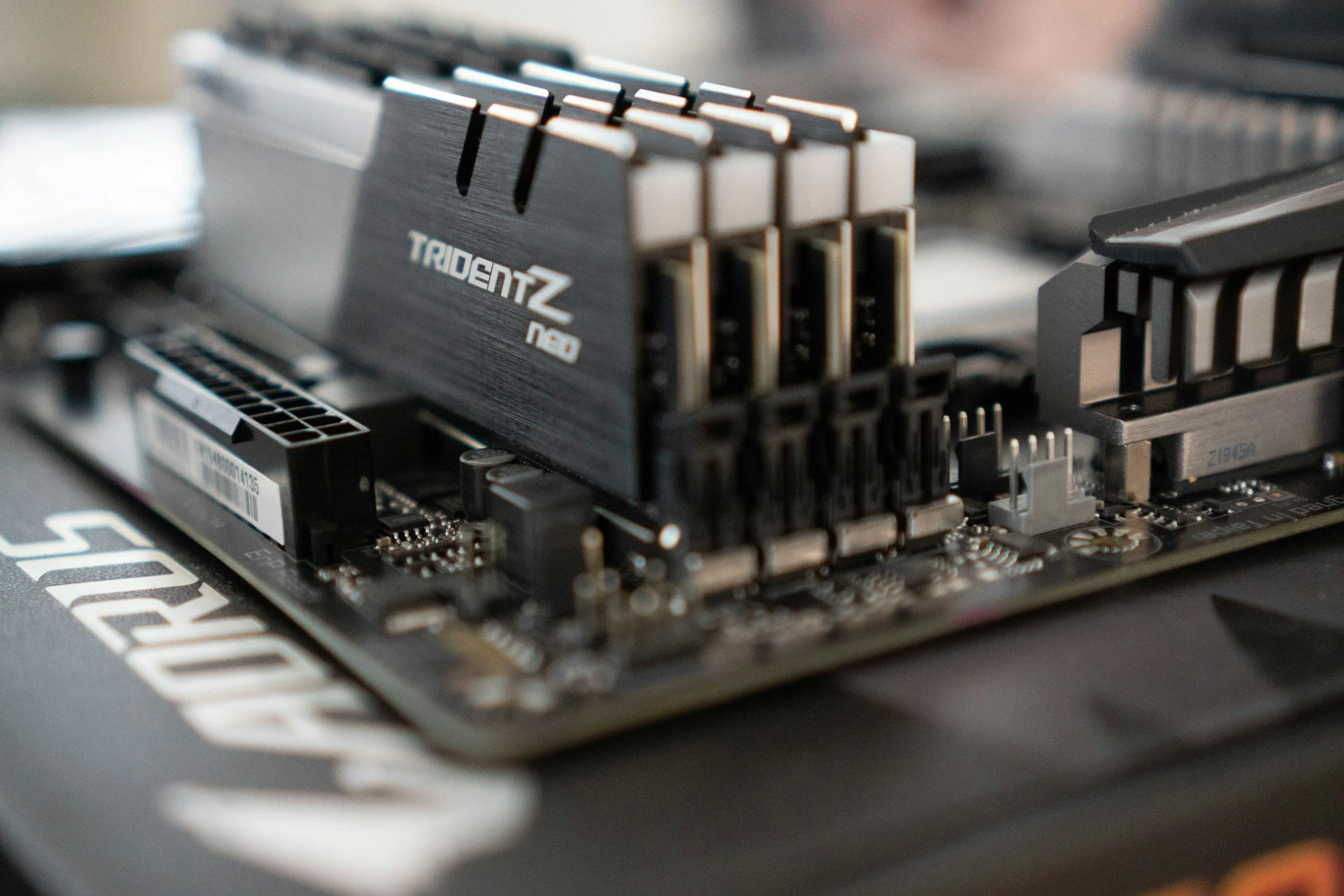 Close-up of a computer motherboard with a prominent TridentZ Neo RAM module installed.