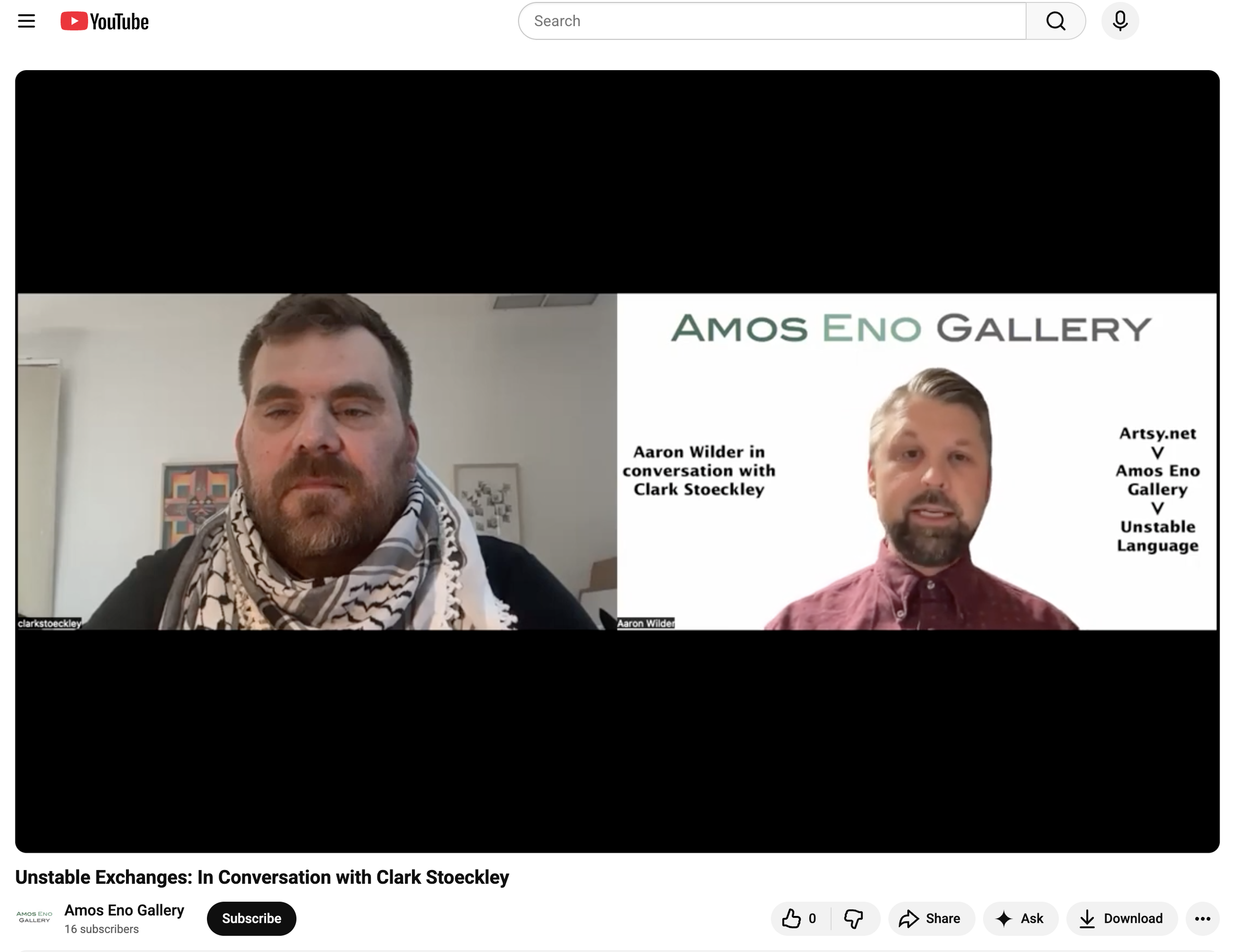 A screenshot from a YouTube video of two men in a virtual conversation. The man on the left has short dark hair, a beard, and is wearing a scarf. The man on the right has short hair, a beard, and is wearing a maroon shirt. The background shows a whit