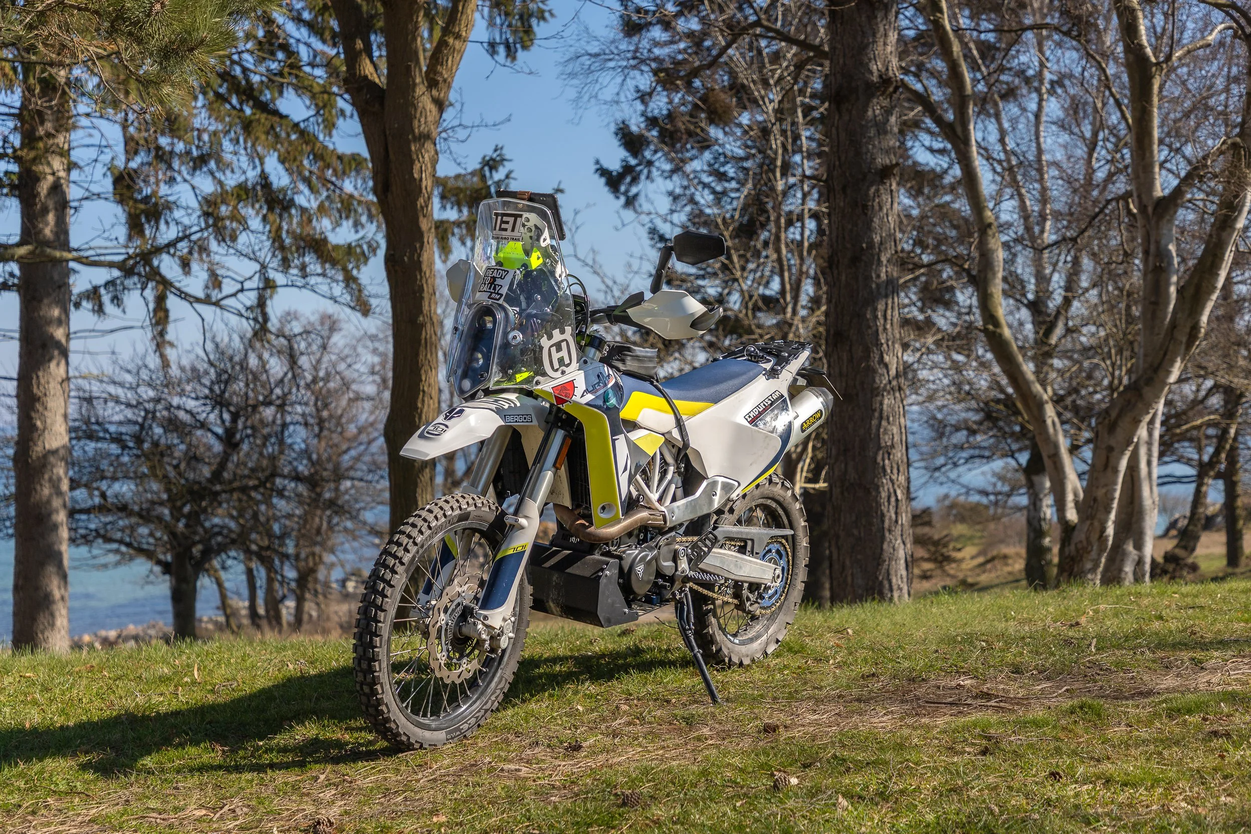 Husqvarna 701 enduro on a lawn in front of trees