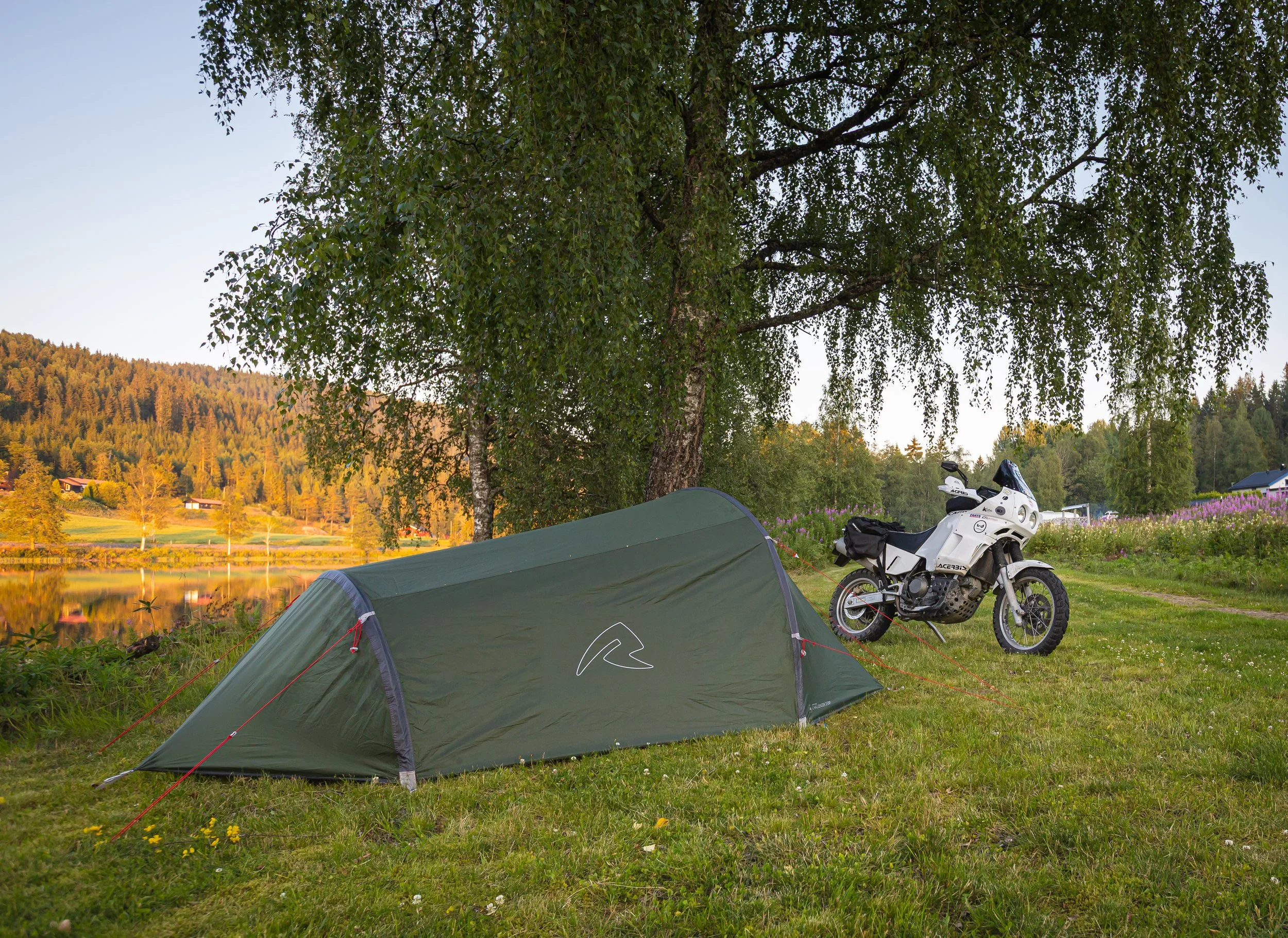 Motorcycle at camping site in Norway by a lake