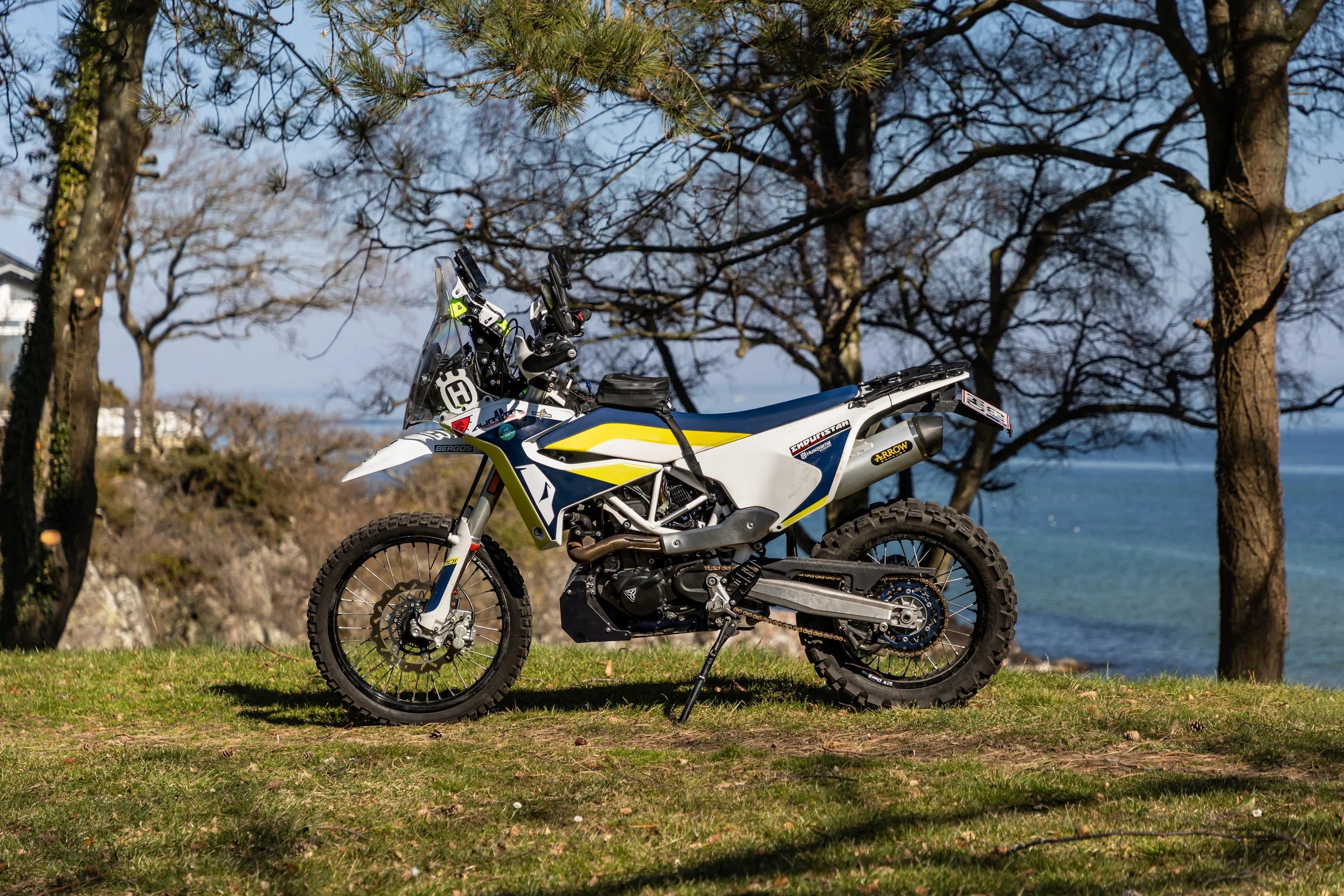 Husqvarna 701 enduro on a lawn in front of trees