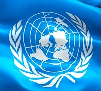 United Nations emblem featuring a world map surrounded by olive branches on a blue background.