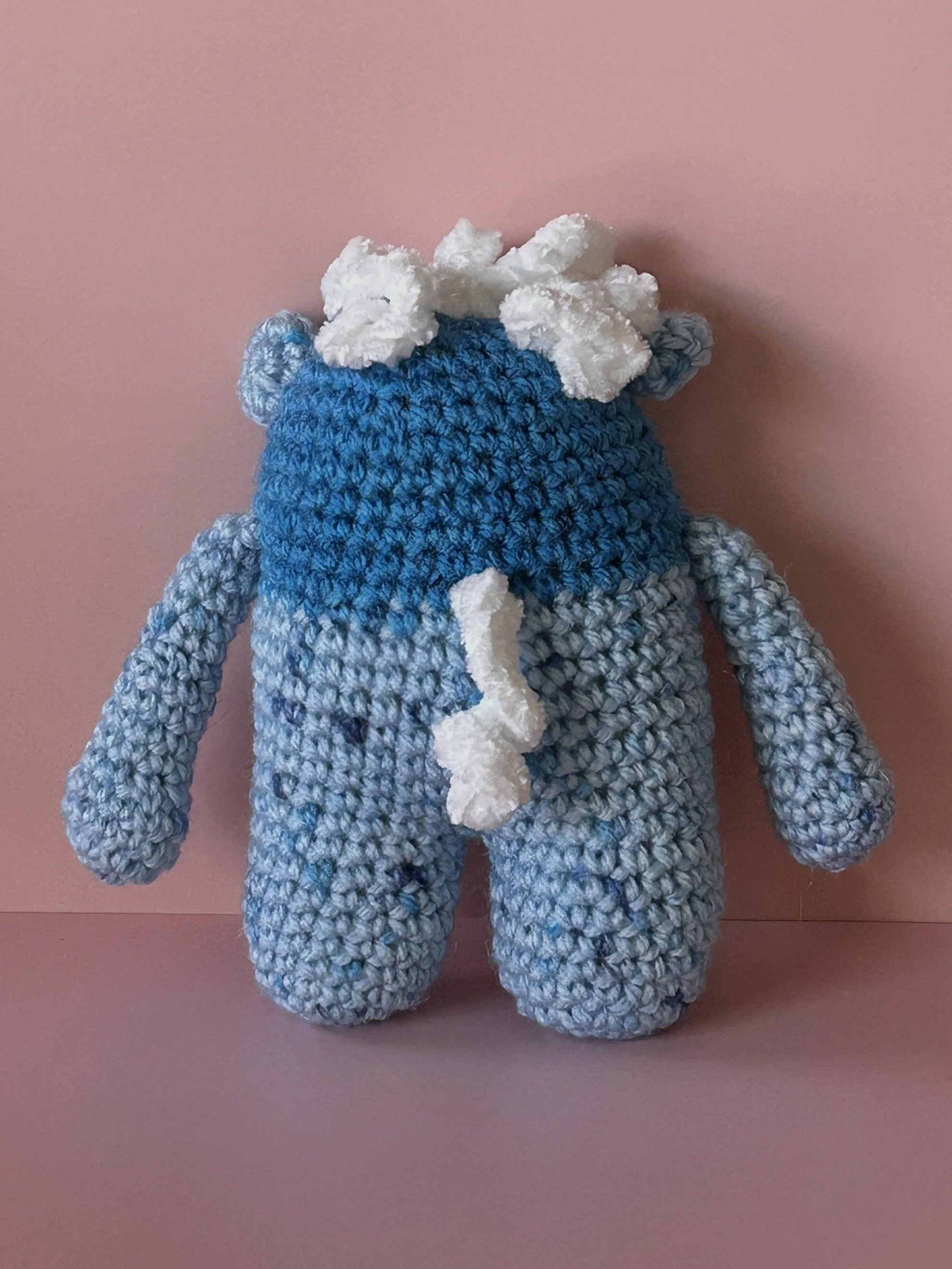 Snowbeard back of blue monster with curly white hair and white squigglyy tail