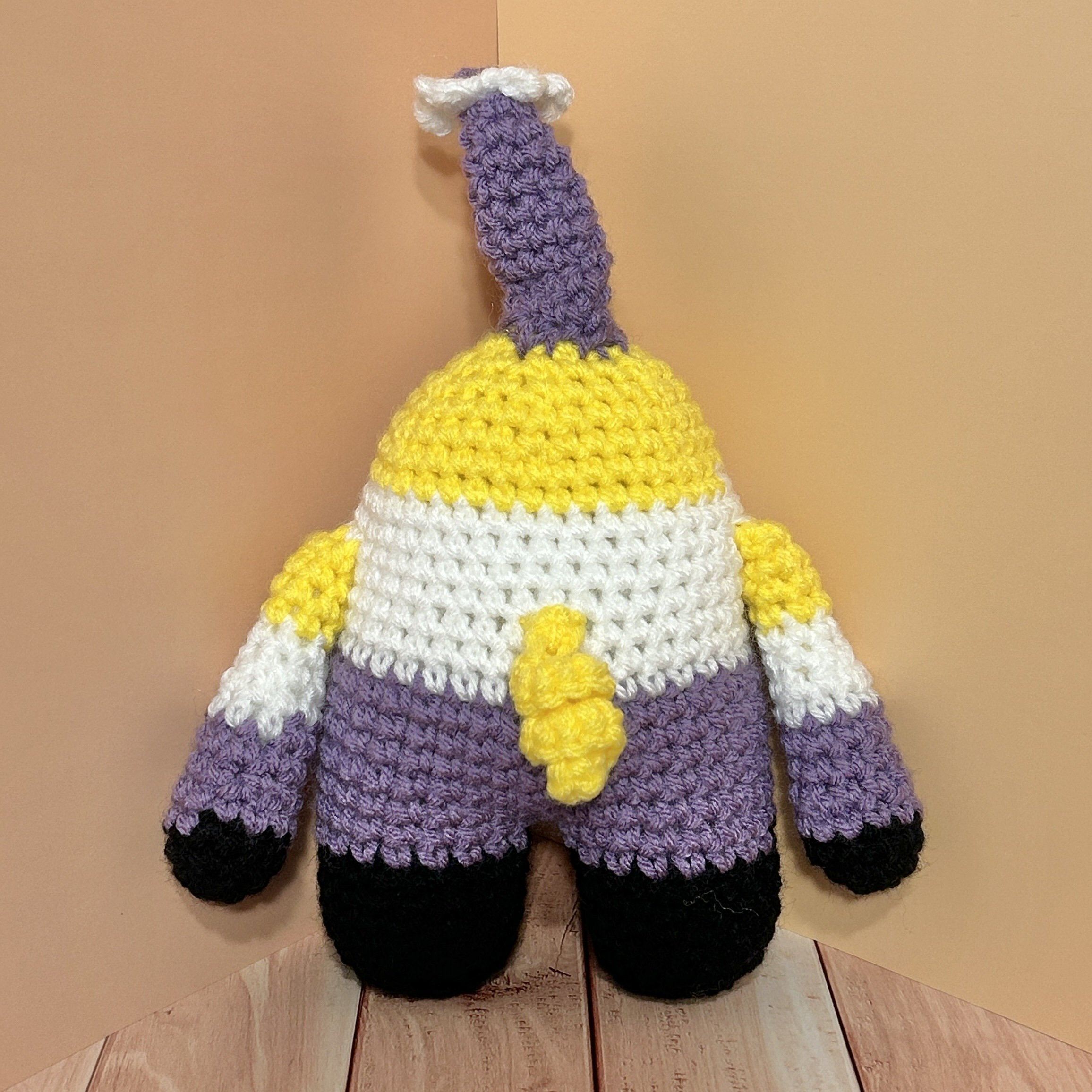 Kye back of yellow white purple black striped monster with curly yellow tail and purple horn