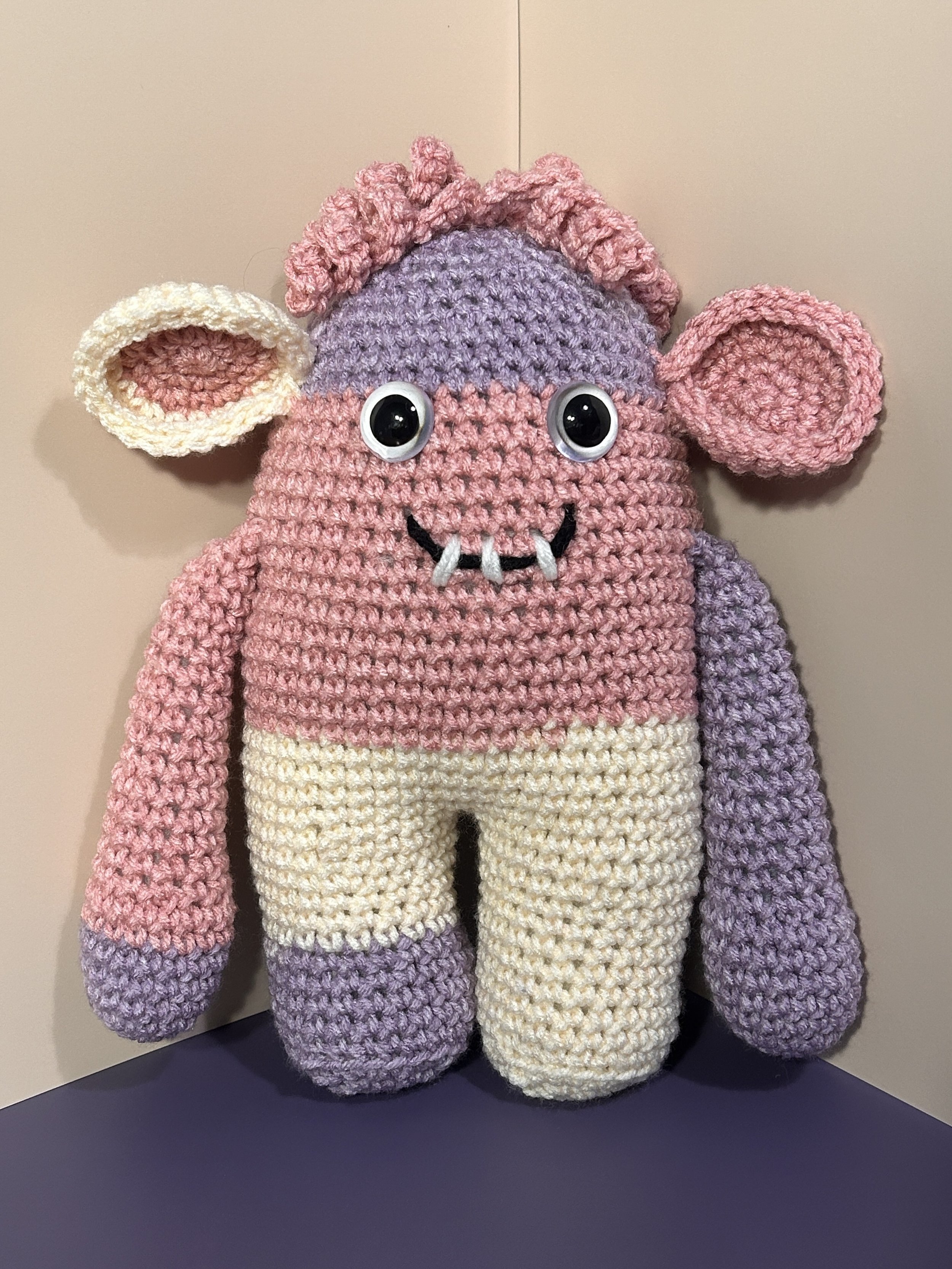 MooMonster light purple pink and white monster with cow ears pink squiggly hair smiling with 3 teeth