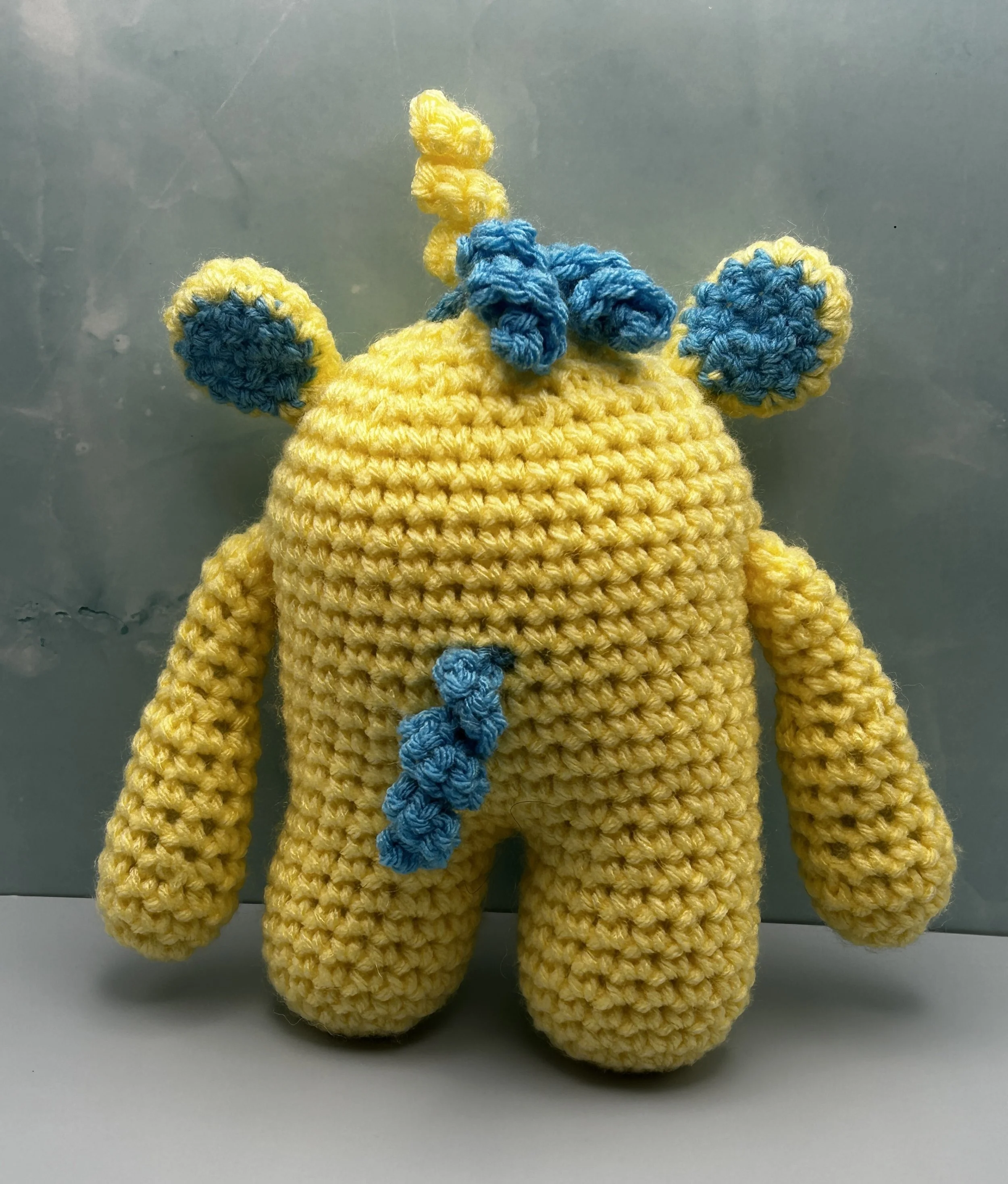 Flora back of daffodil yellow monster with curly blue tail