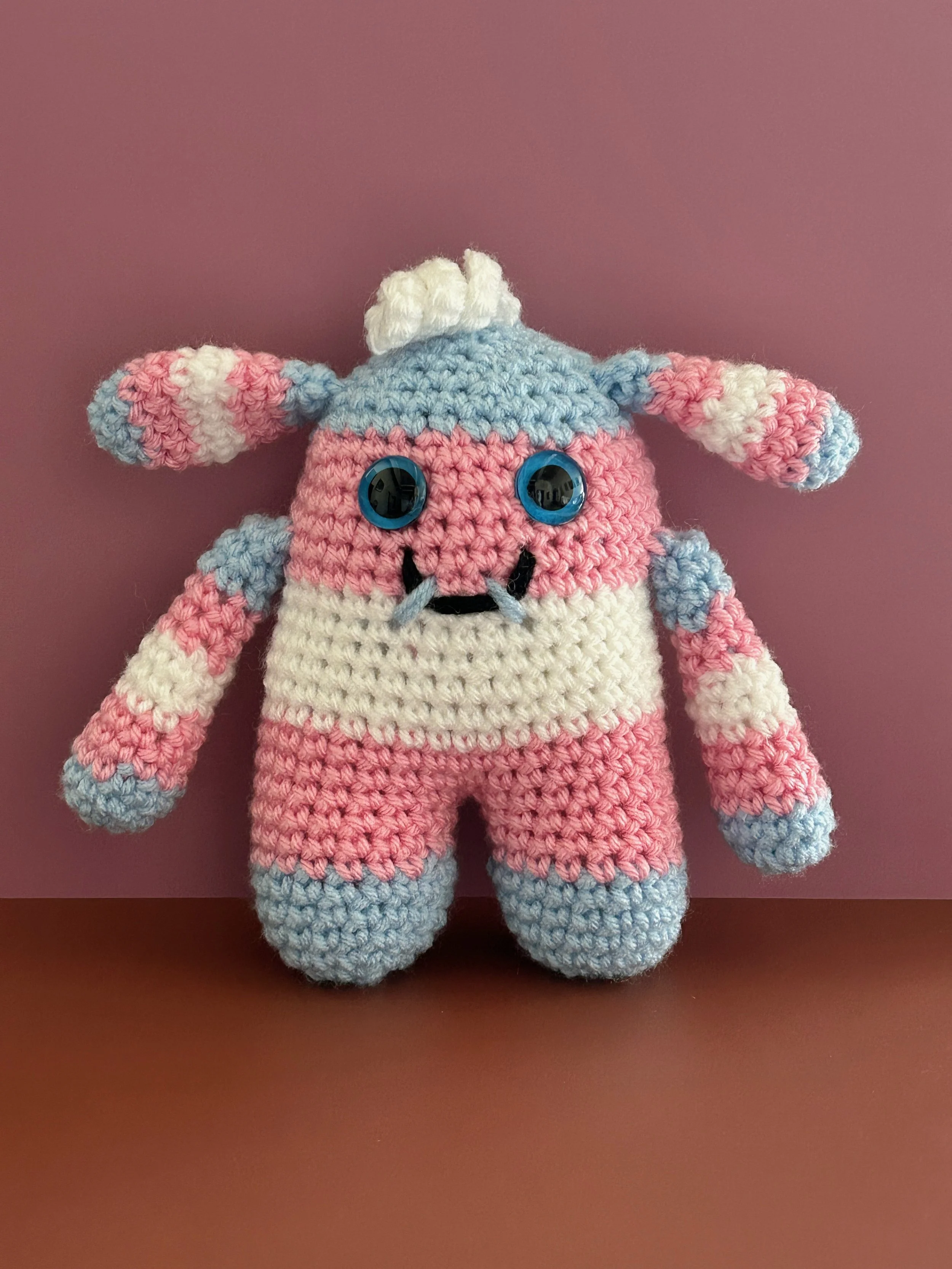Transgender Pride Flag Monster light blue, pink, white stripes bunny ears blue googly eyes smiling with 2 teeth