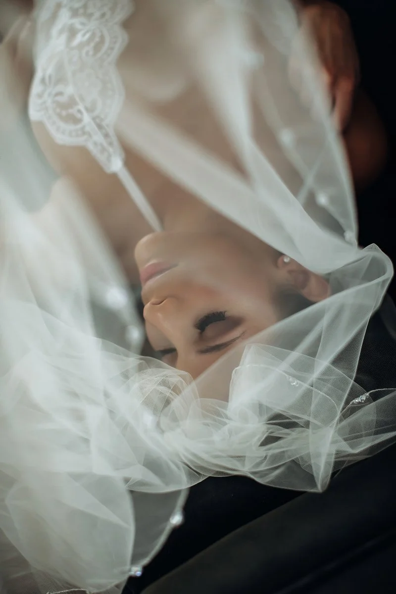 Close-up bridal boudoir portrait of a bride's face wrapped in delicate wedding veil tulle, Boudoir by Emily, Beaufort SC