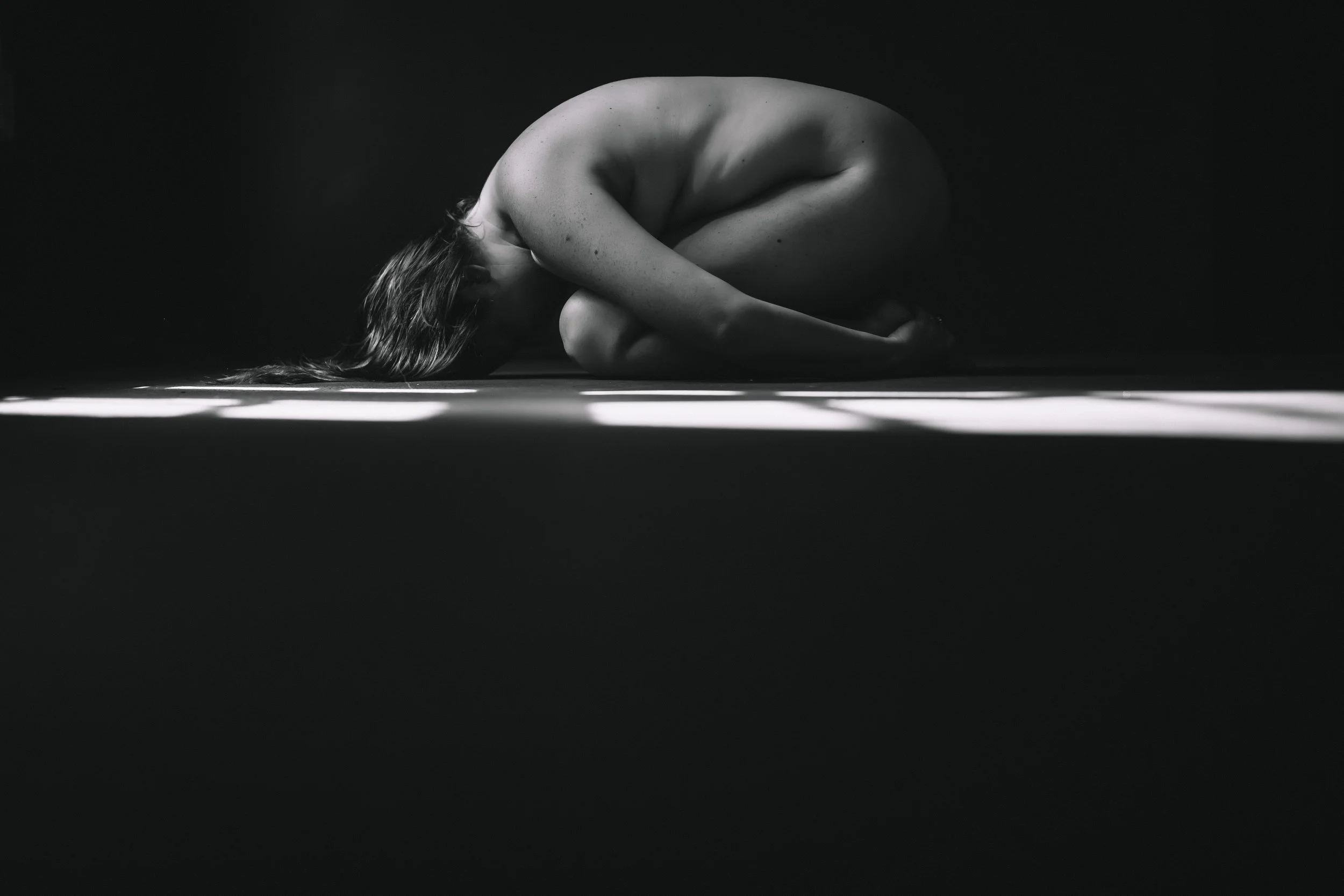 Artistic fine art nude portrait with dramatic light stripes across the floor, woman in a restful pose, The Raw Project, Boudoir by Emily, South Carolina