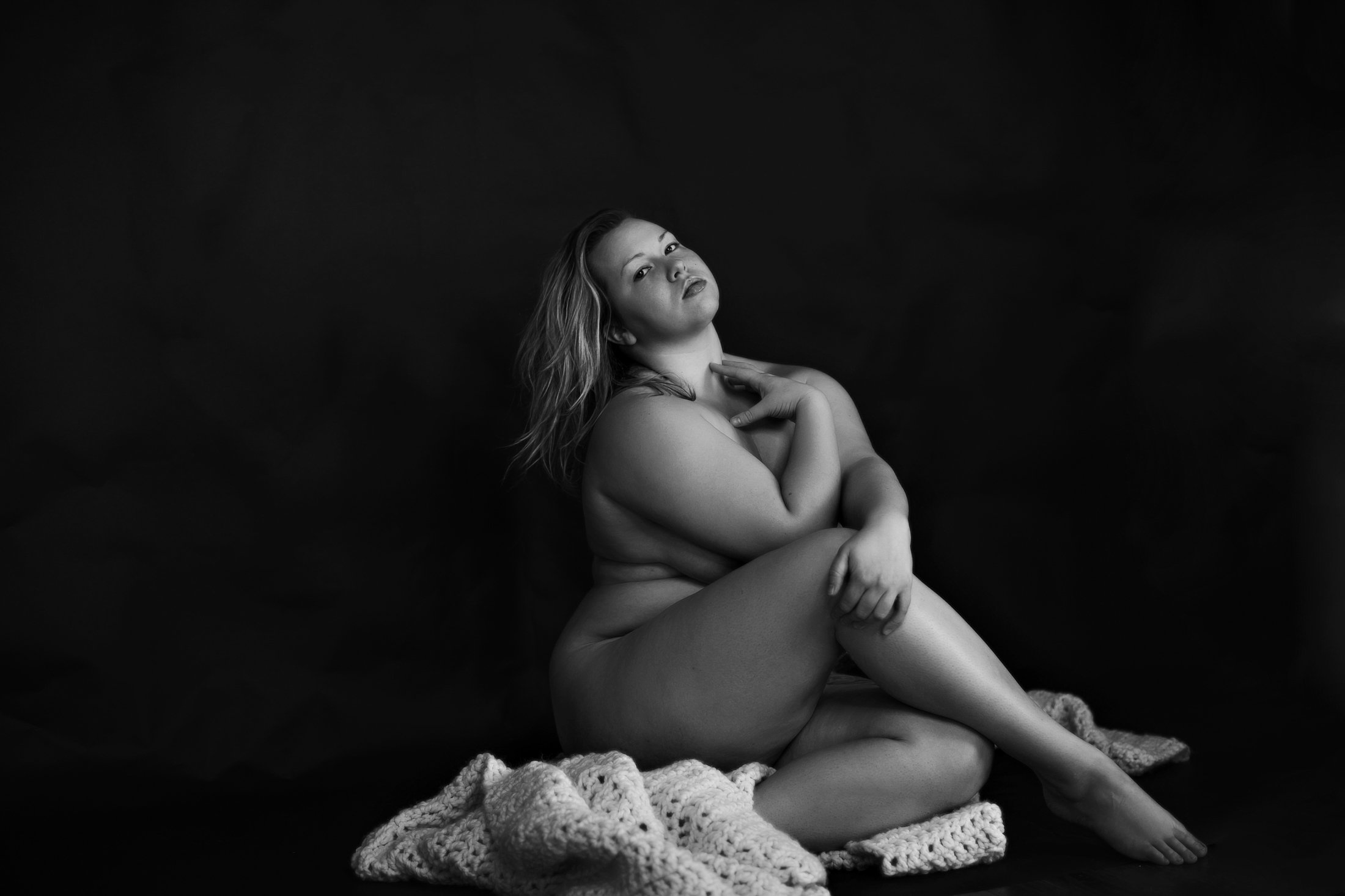 Natural raw portrait of a woman wrapped in knit fabric against a dark background, The Raw Project, Lowcountry SC