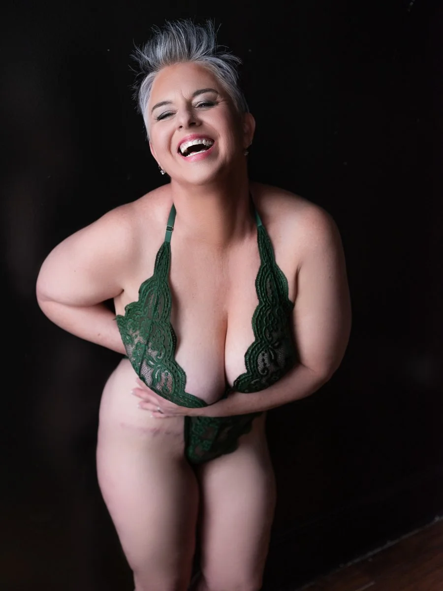 Joyful woman with silver spiked hair laughing in green lace lingerie, empowering boudoir portrait, Boudoir by Emily, Beaufort SC