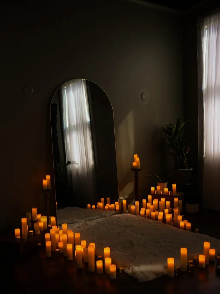 Dark and Moody candlelight boudoir scene with arched mirror surrounded by glowing candles, intimate fine art photography studio, Bay Street Studios, Beaufort SC
