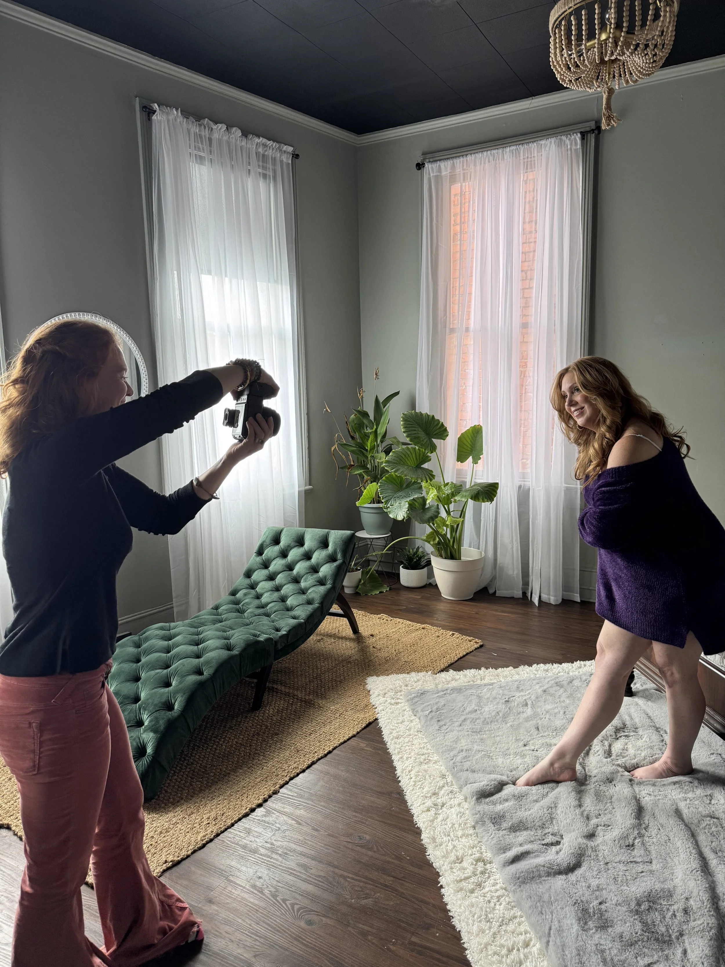 A joyful behind the scenes moment capturing the warm and fun energy of a boudoir session with Emily Scott at Bay Street Studios in Beaufort, SC.