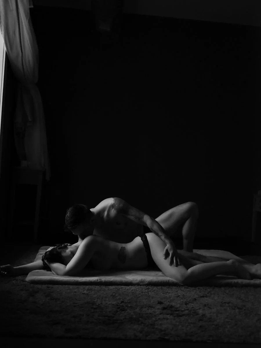 Black and white couples boudoir portrait of two partners in an intimate embrace on a rug near a window, Boudoir by Emily, South Carolina