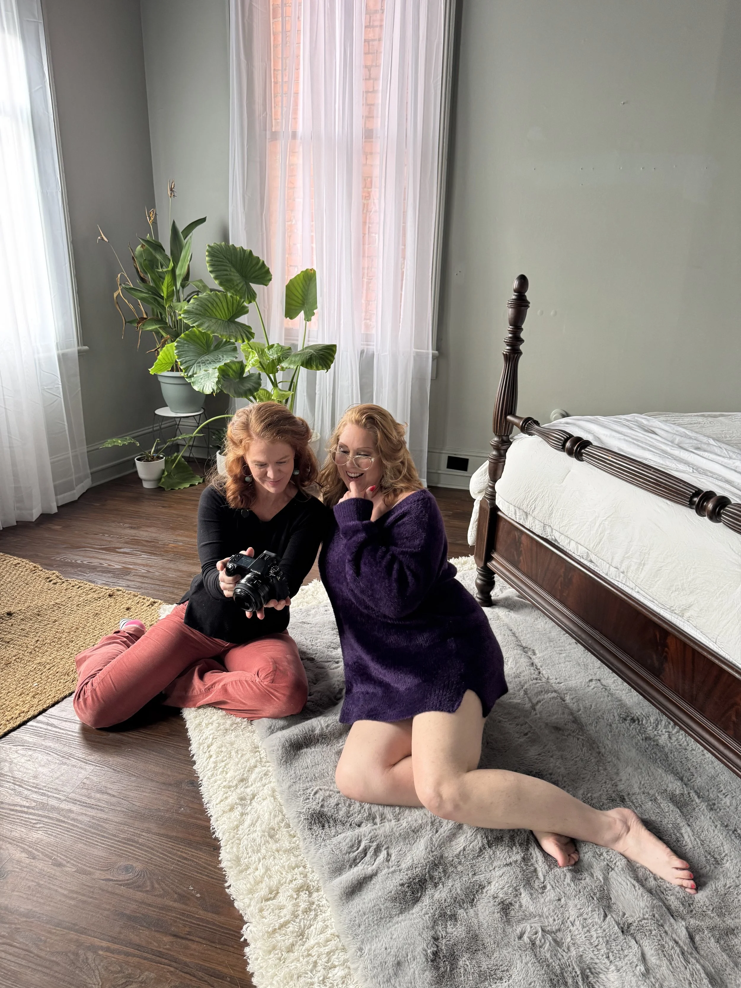 Boudoir photographer Emily Scott showing a client her images on camera for the first time at Bay Street Studios, both laughing and smiling, Beaufort SC