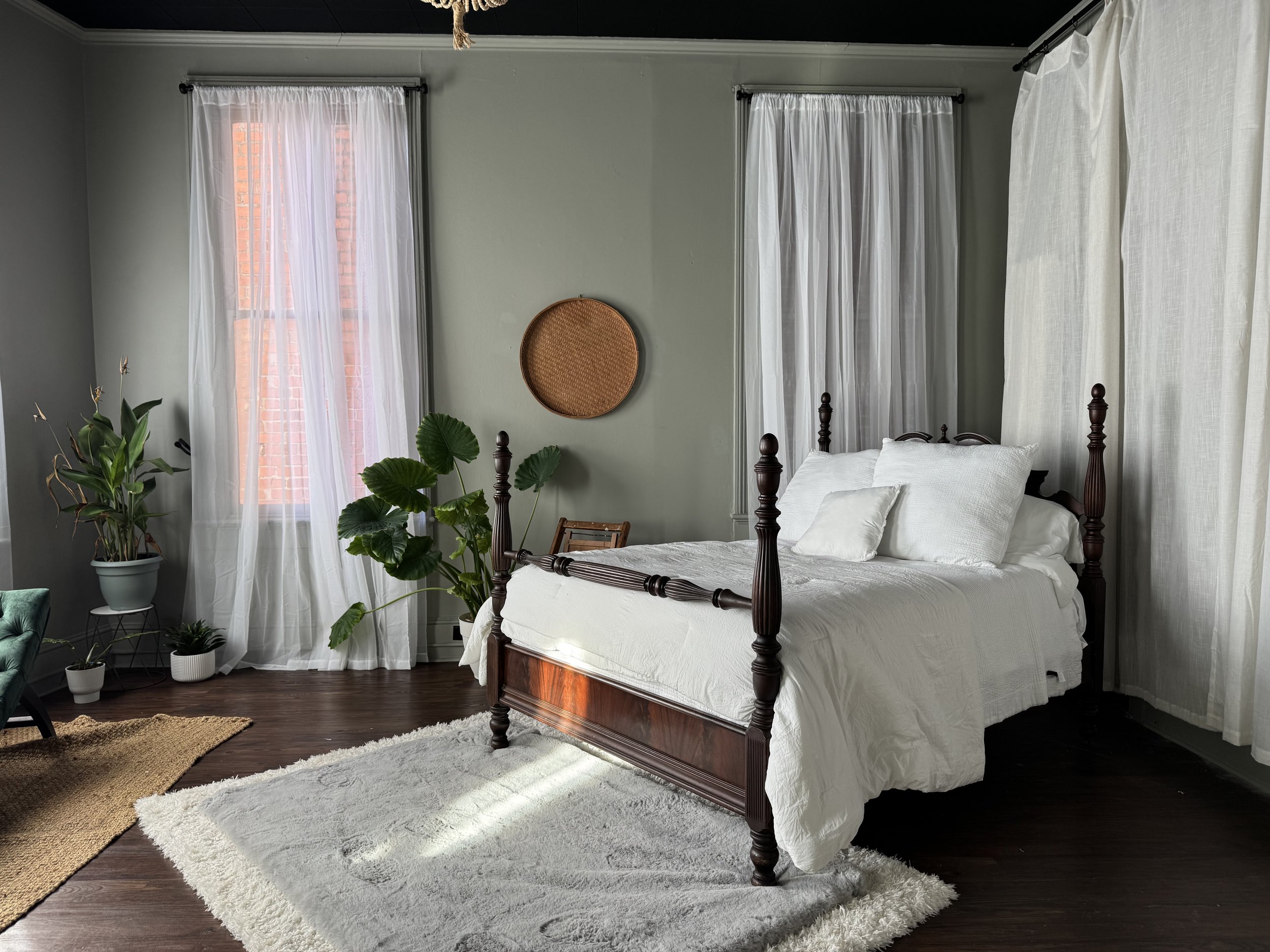 Four-poster bed with white linen bedding and tall sheer curtained windows, natural light boudoir studio, Bay Street Studios, Beaufort SC