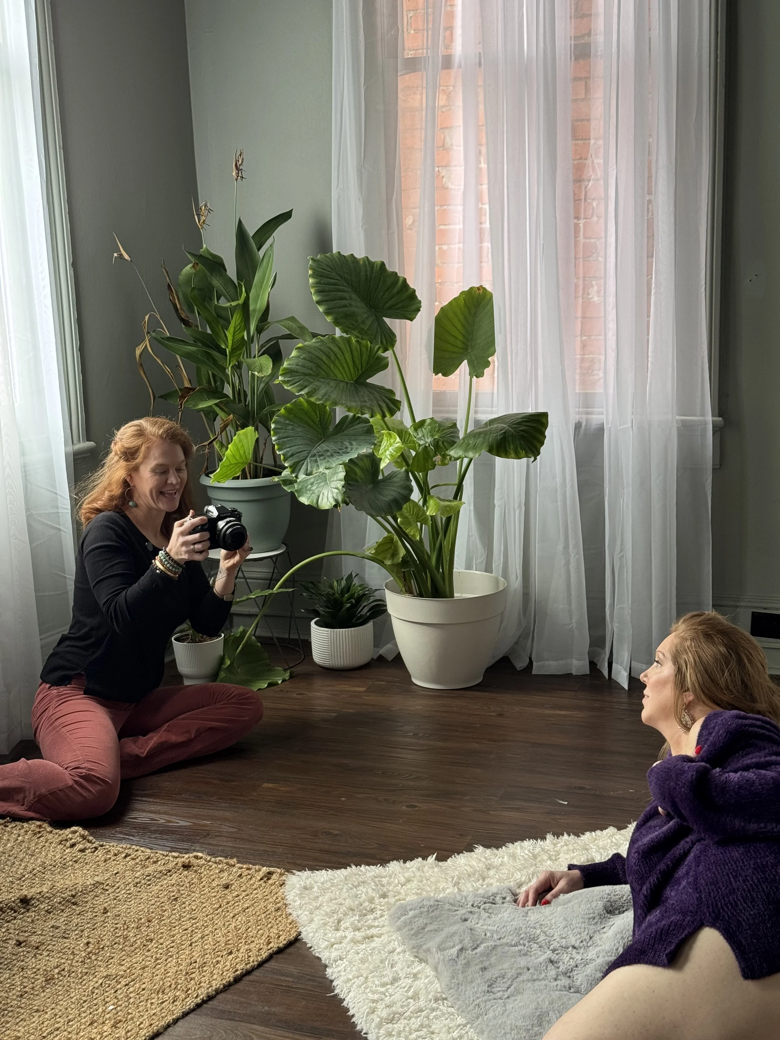 An authentic behind the scenes moment showing the genuine warmth and joy of a boudoir photography session with Emily Scott at Bay Street Studios in Beaufort, SC.