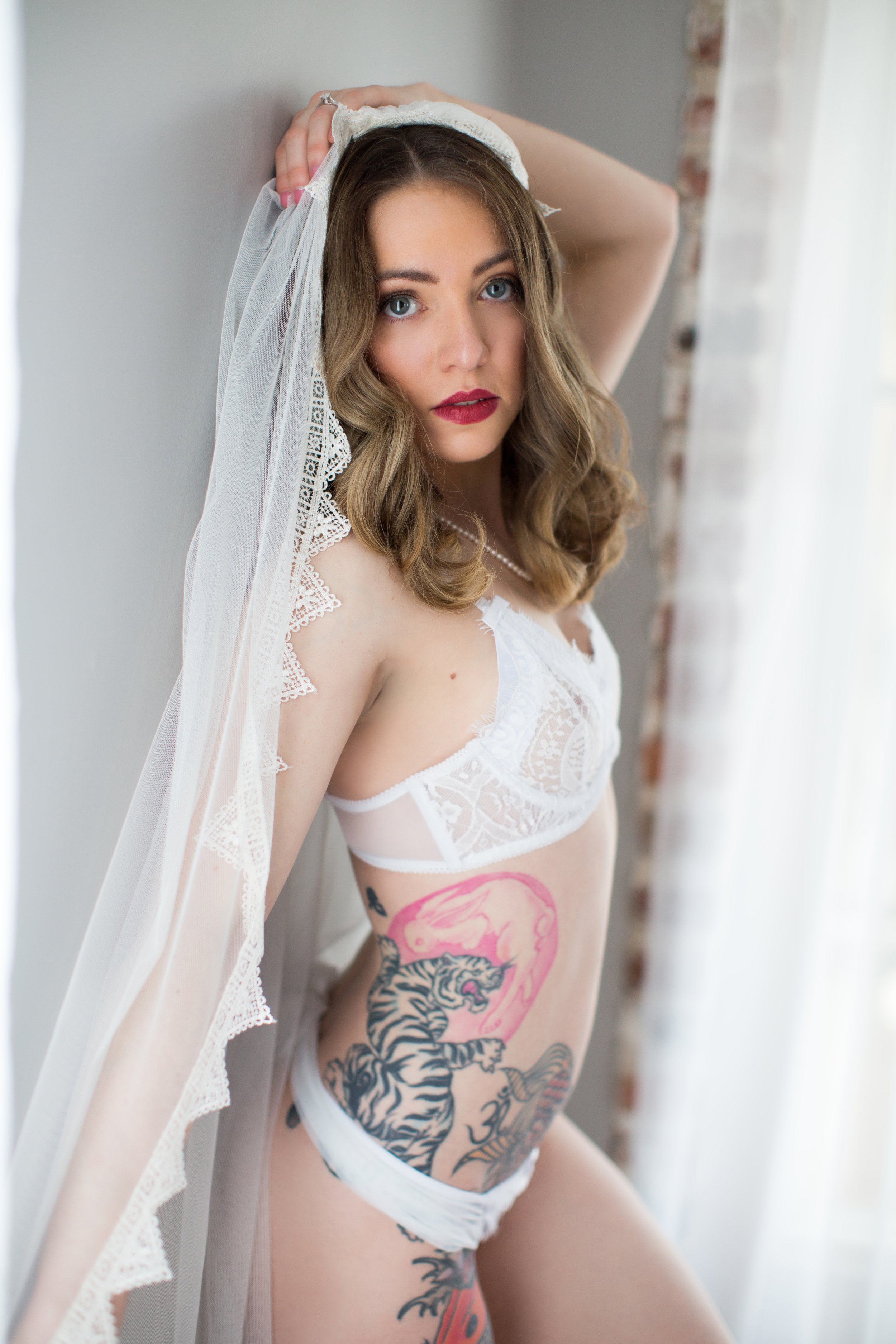 An intimate black and white bridal boudoir portrait of a bride wearing a wedding veil, fine art photography by Emily Scott at Bay Street Studios in Beaufort, SC.