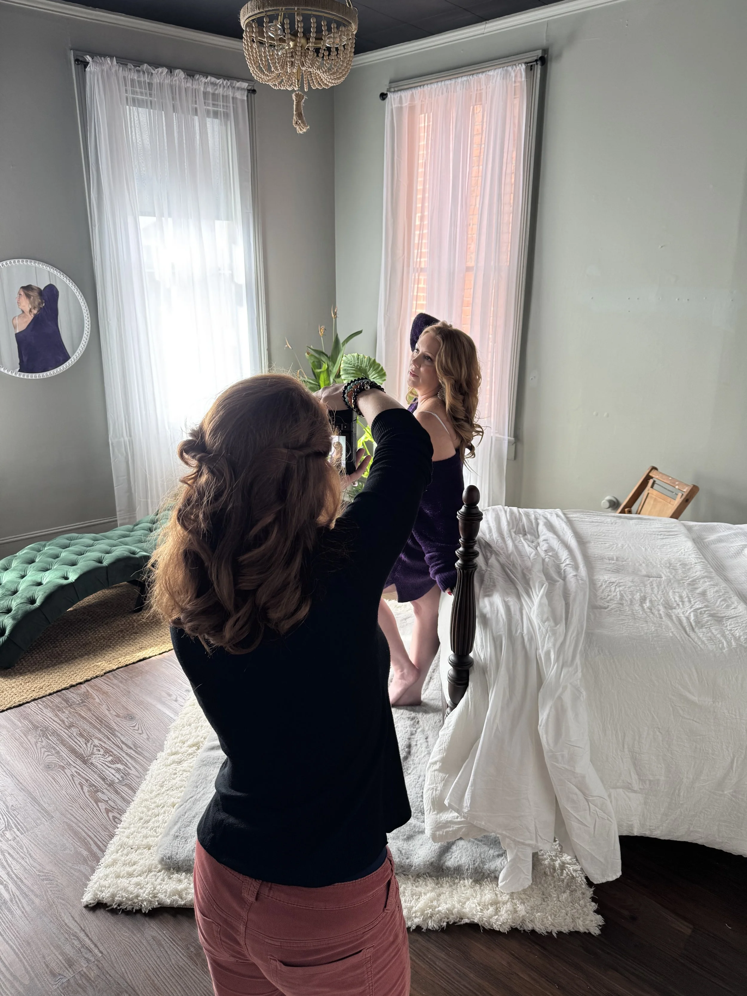 A behind the scenes photograph of boudoir photographer Emily Scott at work during a natural light session at Bay Street Studios in Beaufort, SC.