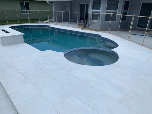 Marble paver deck around a pool and spa in West Palm Beach, FL