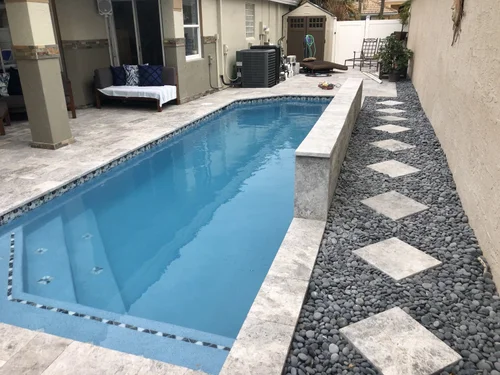 Travertine pool deck with stepping-stone side path in Palm Beach Gardens, FL