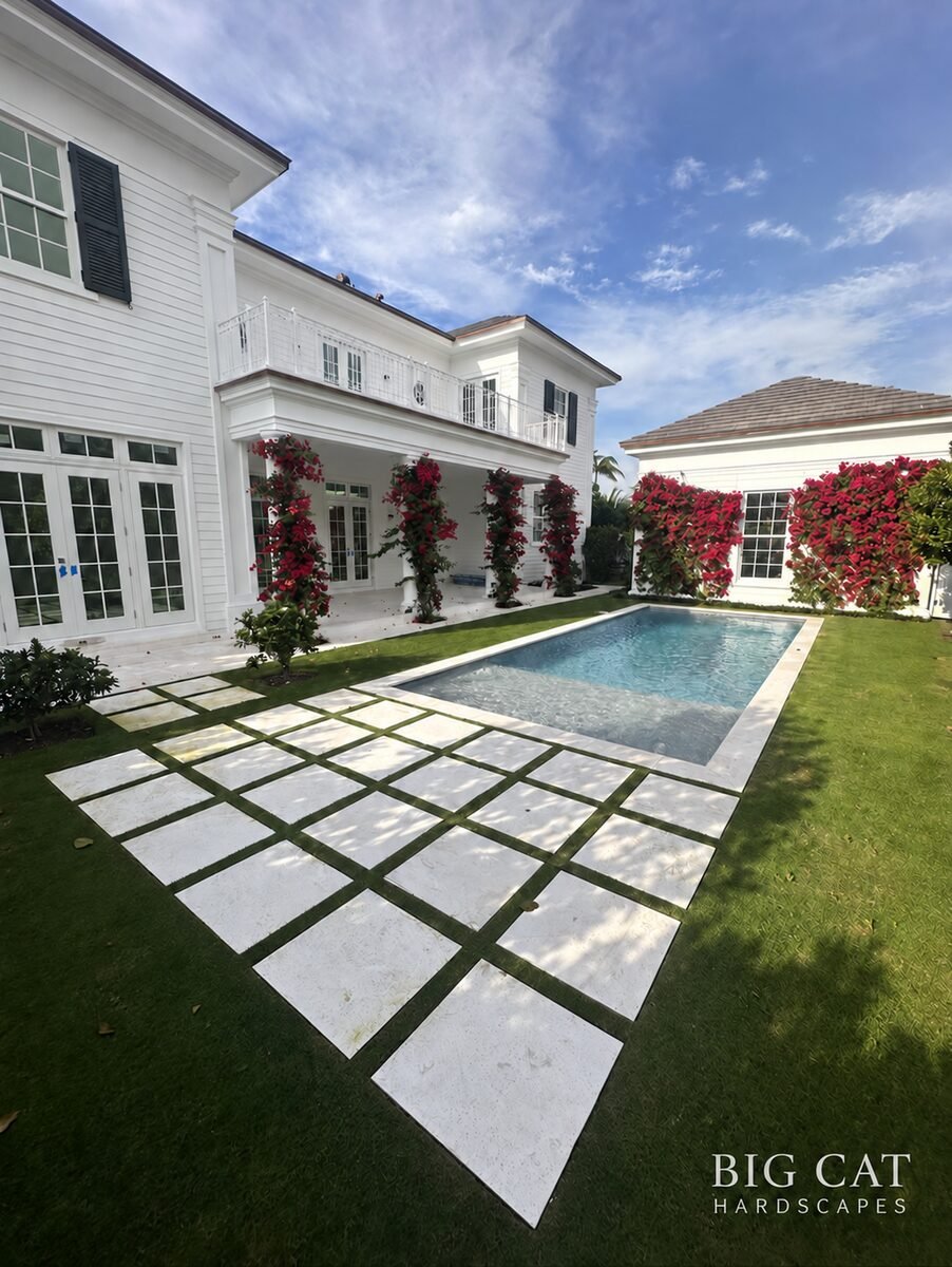 Luxury white marble pool deck and paver walkway by Big Cat Hardscapes in Palm Beach County.