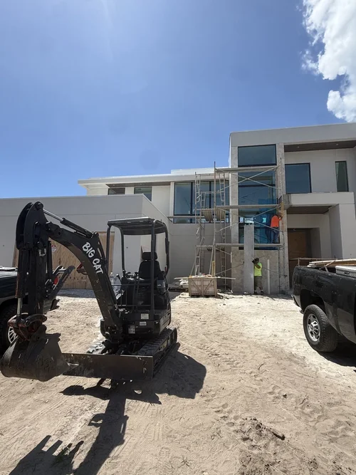 Mini excavator working beside a home