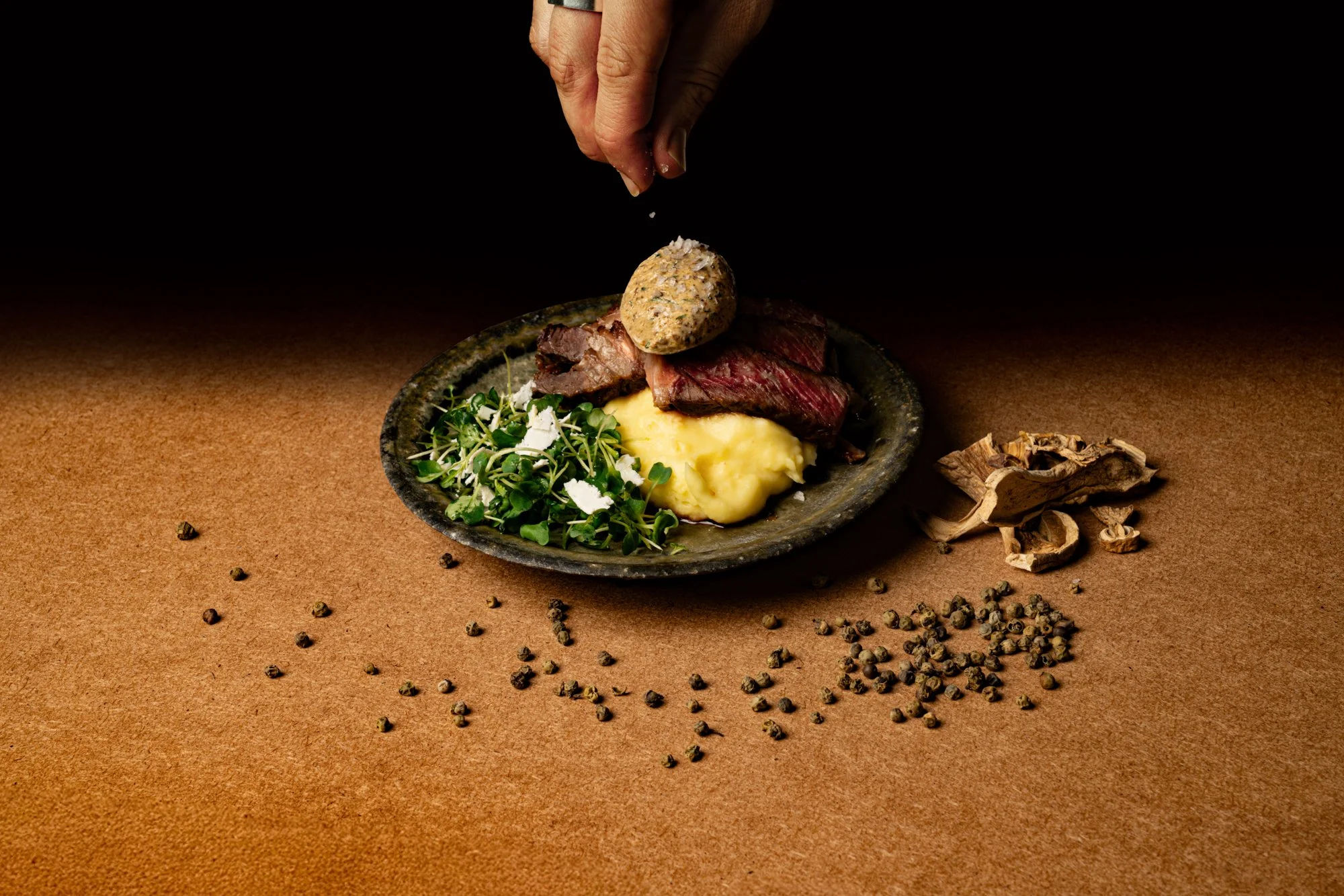 24hr dry-brined ribeye with porcini, green peppercorn and cognac compound butter, bay whipped potatoes and horseradish micro greens with ricotta salata