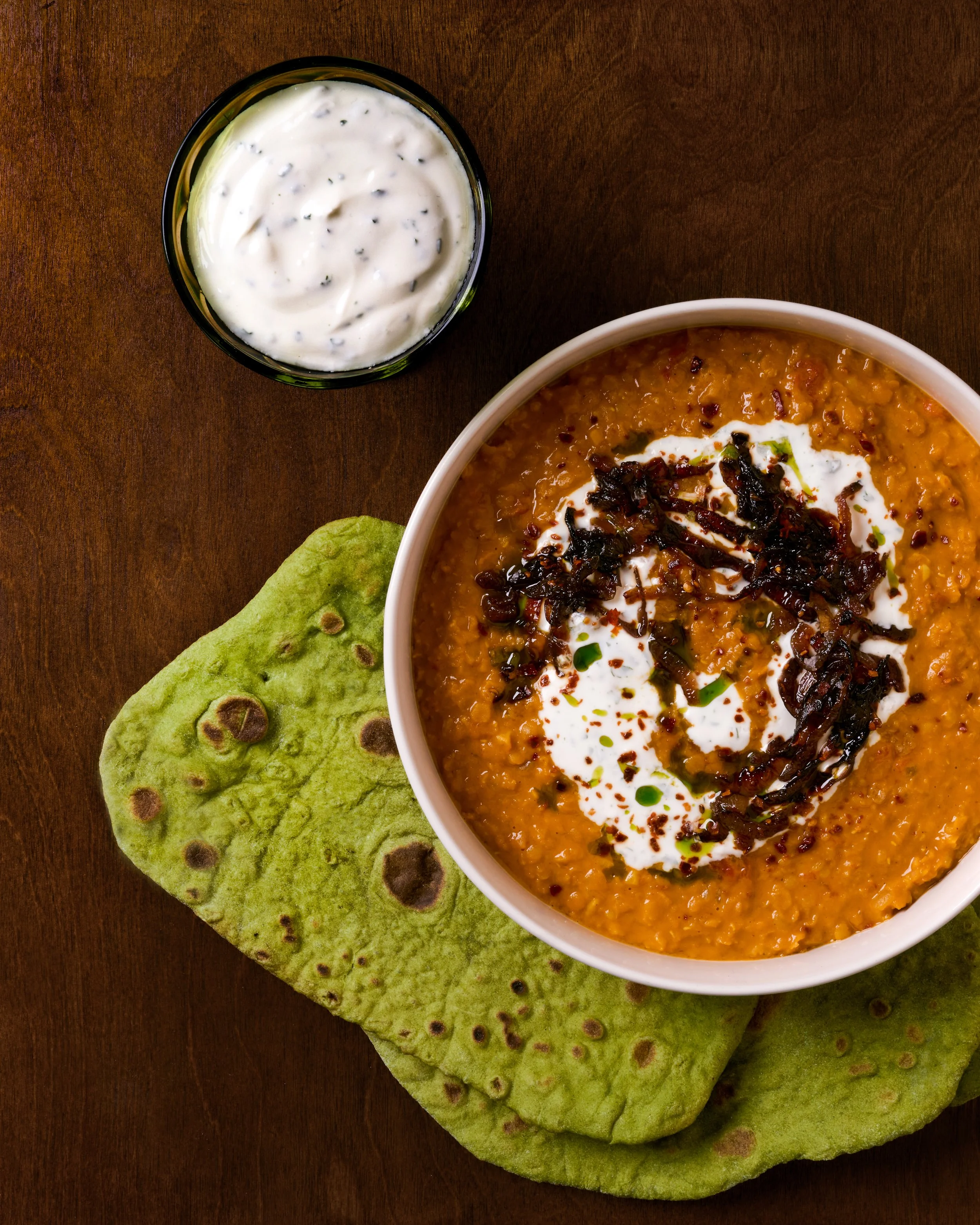 red daal with sticky onions, garlic yogurt, and cilantro oil served with green spinach flatbreads