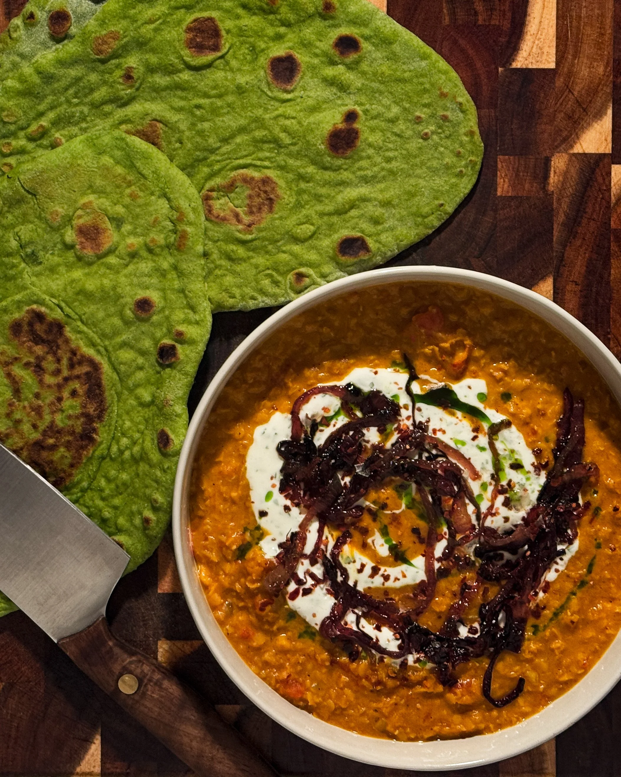 red daal with sticky onions, garlic yogurt, and cilantro oil served with green spinach flatbreads