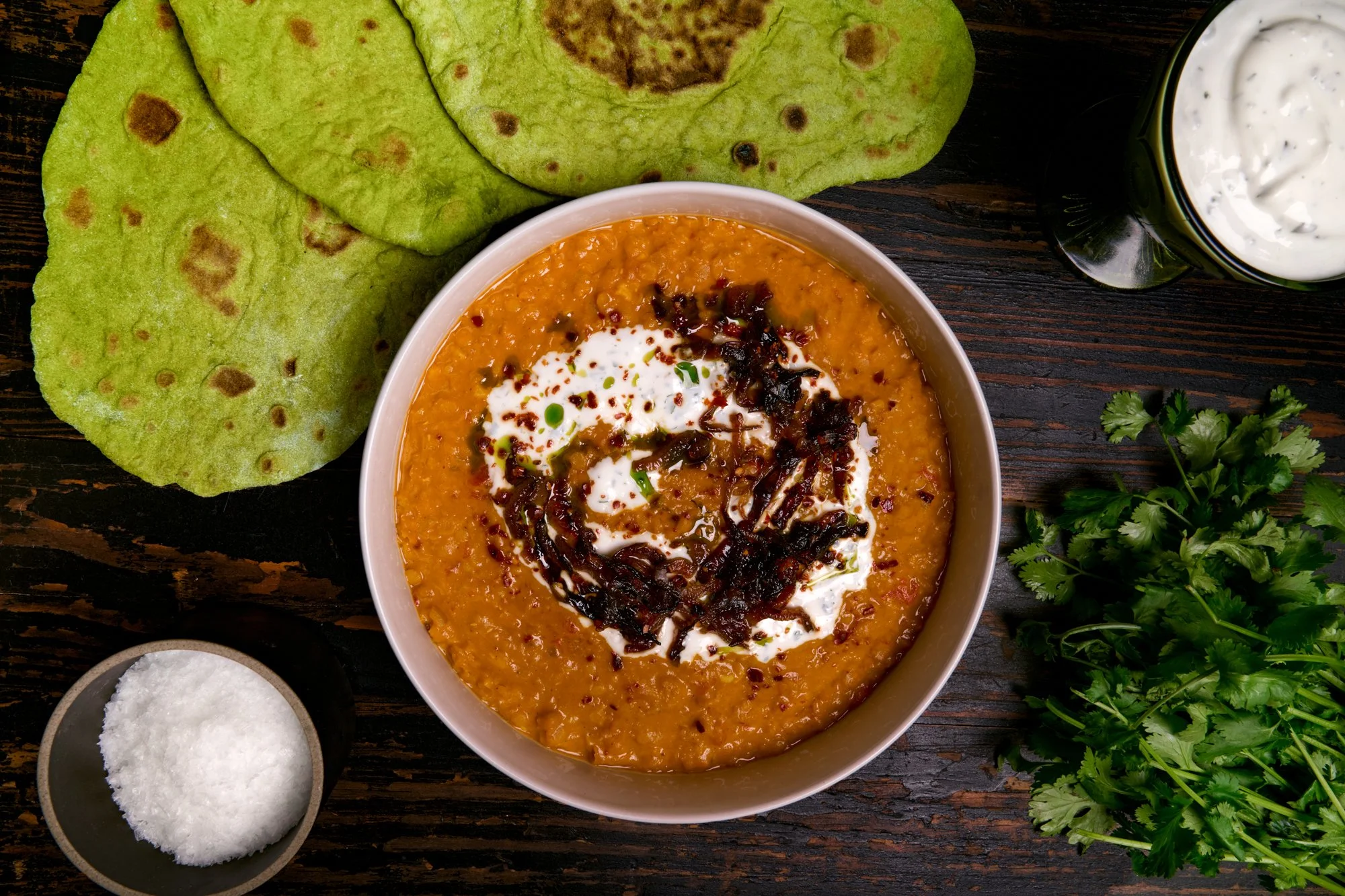 red daal with sticky onions, garlic yogurt, and cilantro oil served with green spinach flatbreads