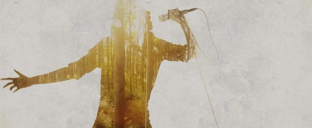 Una figura humana con los brazos extendidos, que contiene la imagen de un bosque con árboles y camino en su interior. Madrid. Metal moderno, metalcore, groove metal y deathcore.