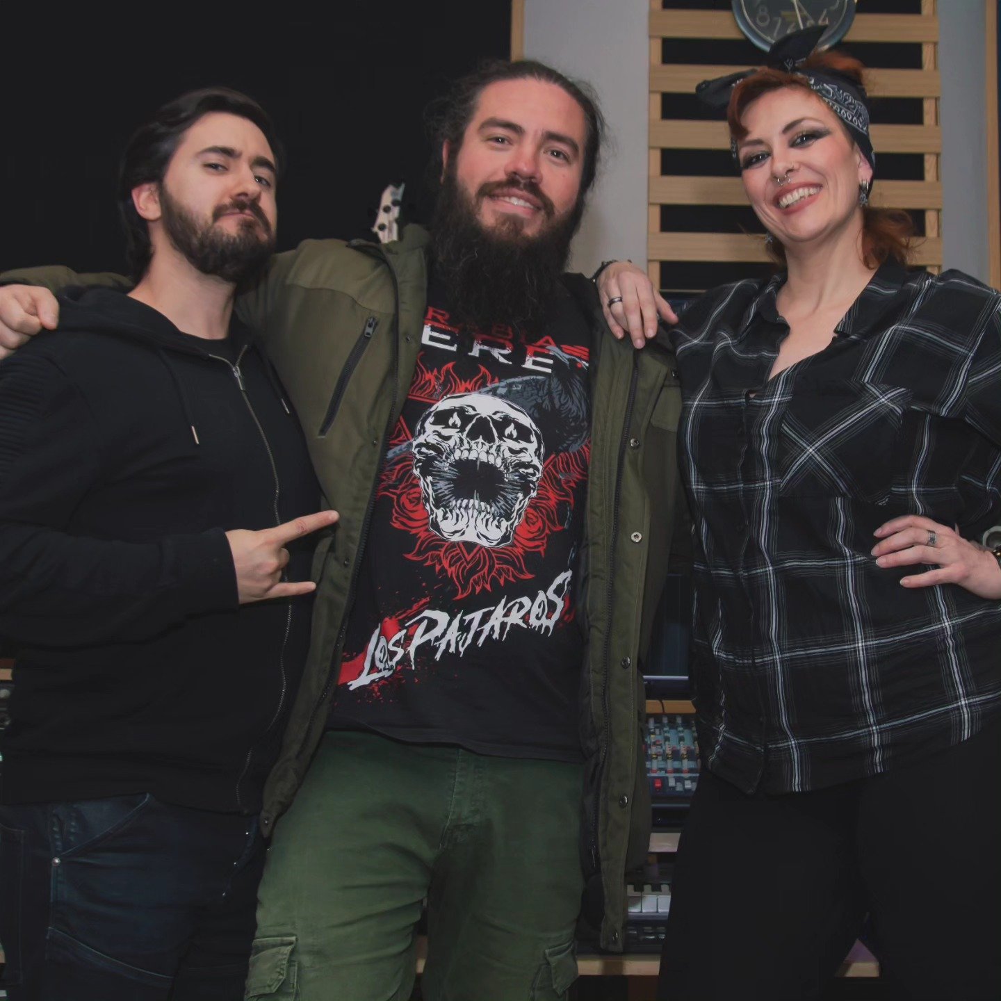 Tres musicos de la banda de Metal moderno, groove metal, metalcore y deathcore Rabia perez posando en estudio de grabación en Madrid, una mujer y dos hombres, uno señala y otra tiene el brazo sobre sus hombros.