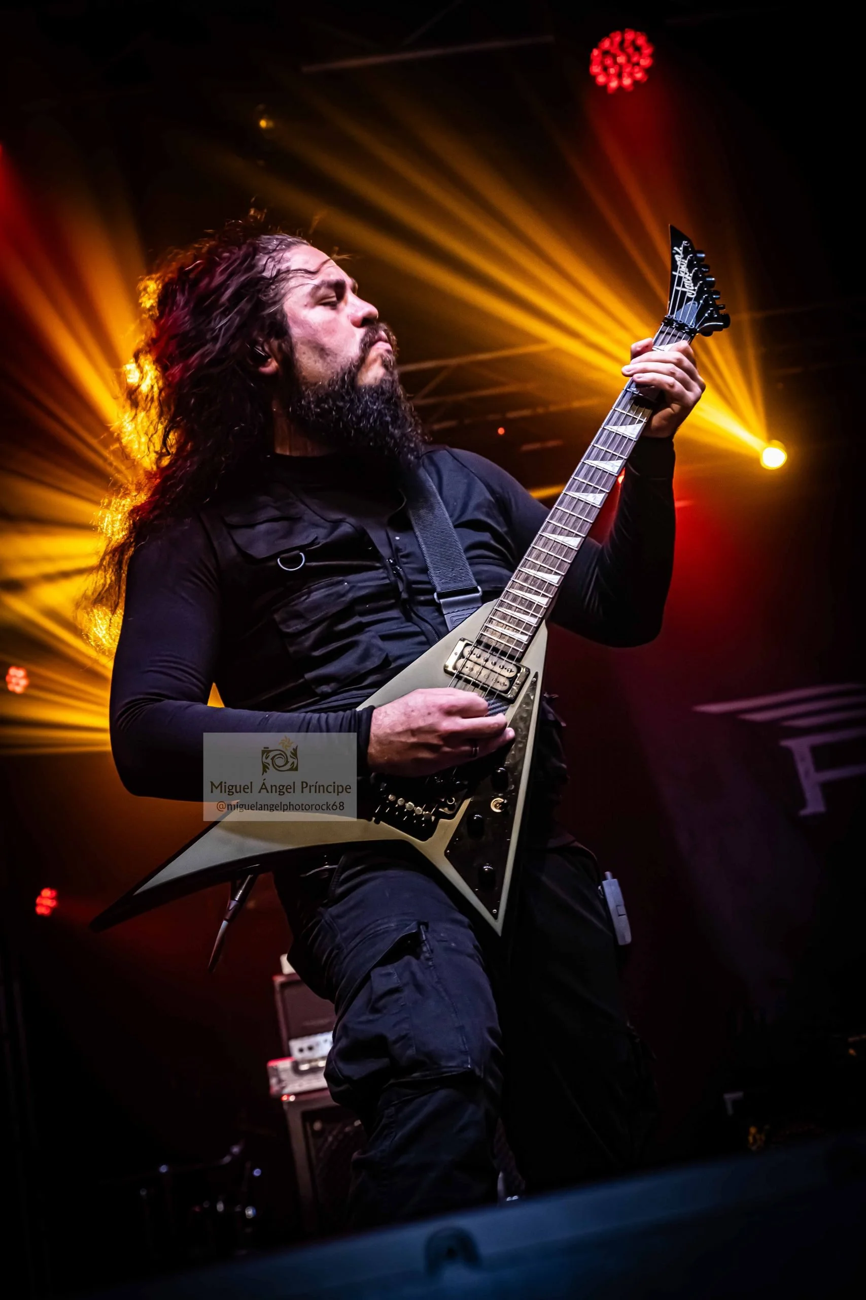 Guitarrista fundadador de la banda Rabia Perez Gabriel Peñasco tocando Metal moderno, groove metal, metalcore y deathcore en un escenario de Madrid con luces rojas y amarillas.