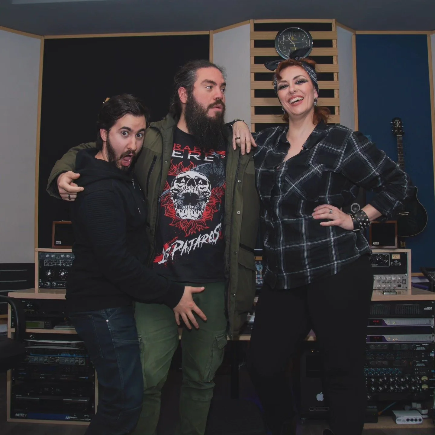 Tres musicos de la banda de madrid de Metal moderno, groove metal, metalcore y deathcore Rabia Perez en un estudio de música, un hombre con barba y camiseta de rock, una mujer con diadema de orejas de conejo negra y una chica con expresión divertida,