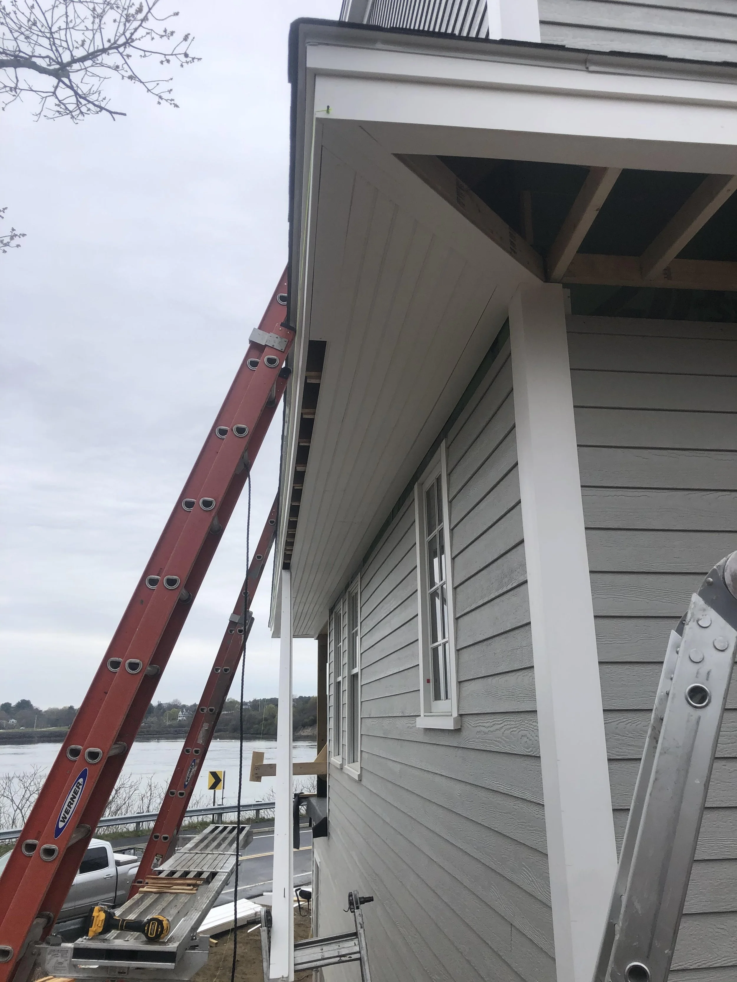 Construction of a house's exterior siding and roof with tools and ladders set up