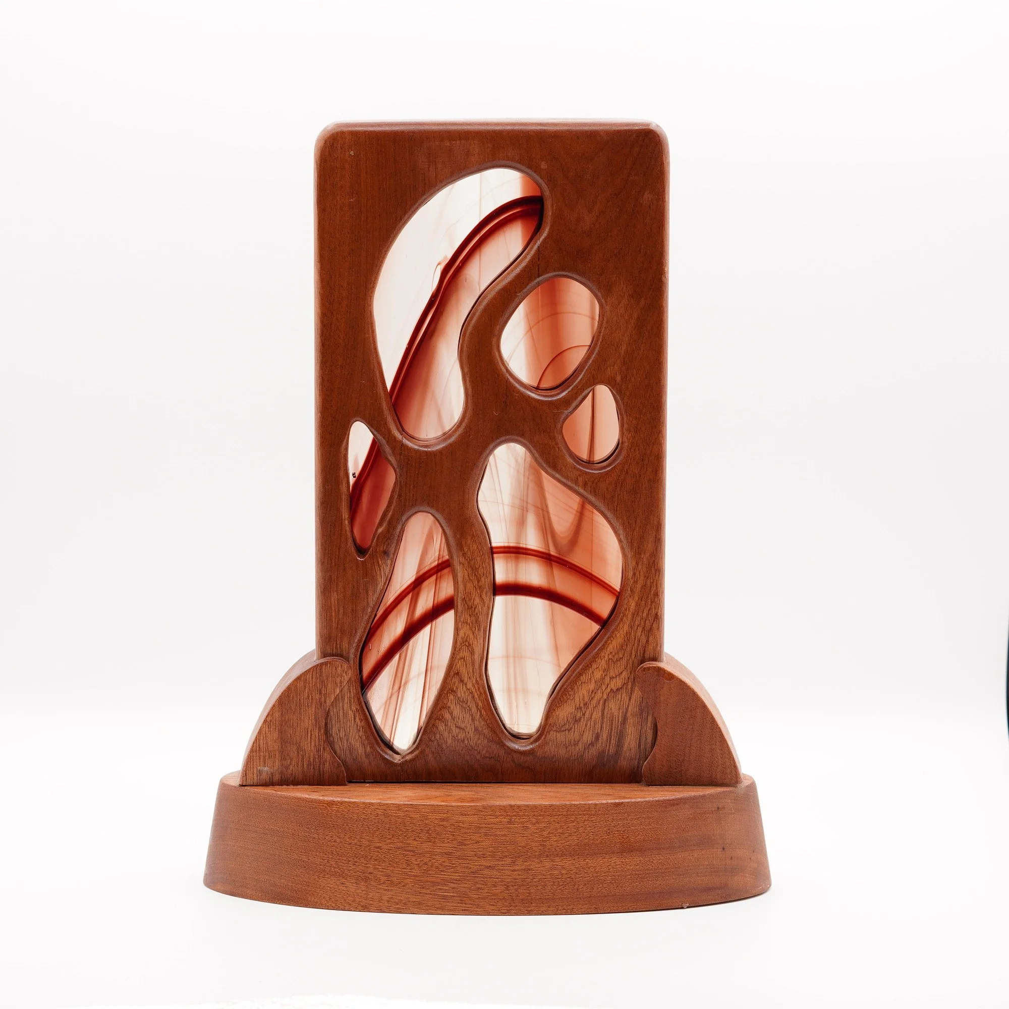 Handcrafted wooden table sculpture with flowing organic curves and a stained-glass accent.