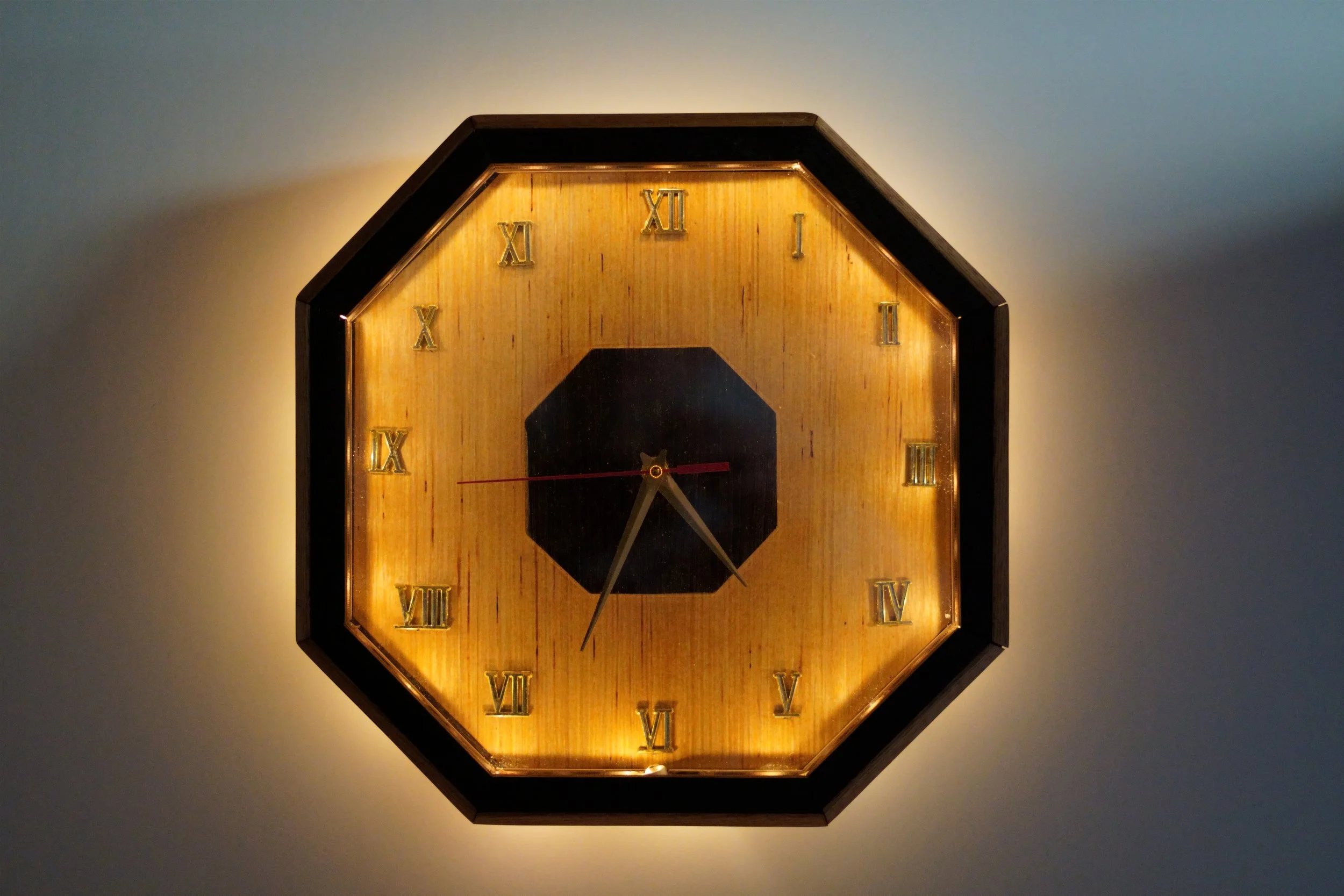 Handcrafted octagon-shaped wooden clock with sculpted edges and natural finish.