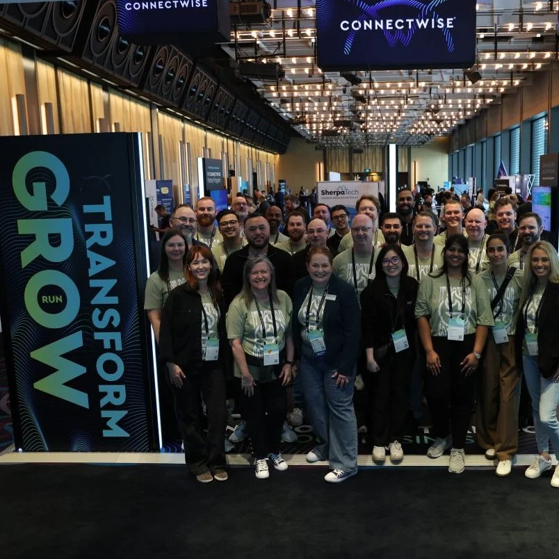 Group of people attending a conference with a sign that reads "Transform Your Growth" at the TransFORUM event, in a large, modern conference hall.