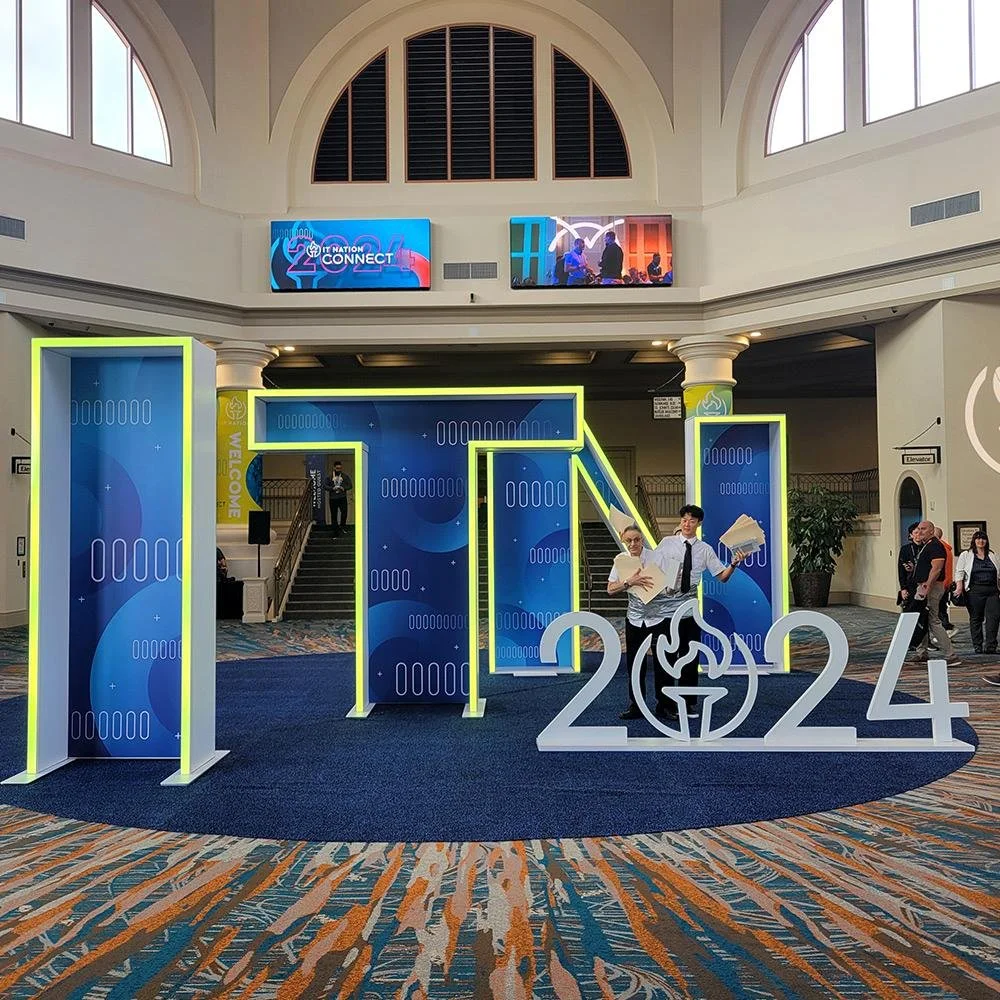 Indoor event with large blue and white-lit 