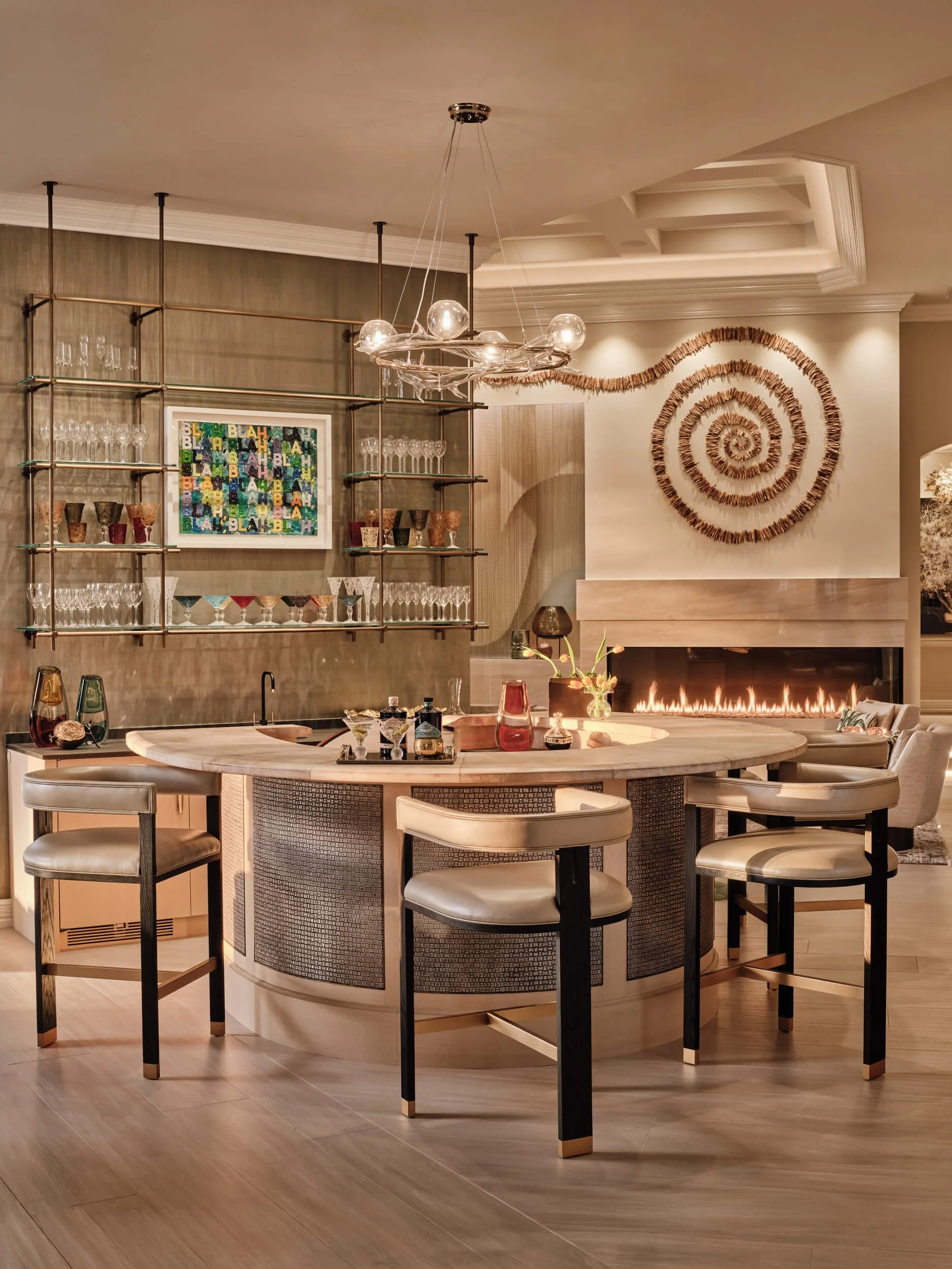 Modern dining area with a round marble table, six chairs, a fireplace, and a wall-mounted sculpture in a well-lit room.