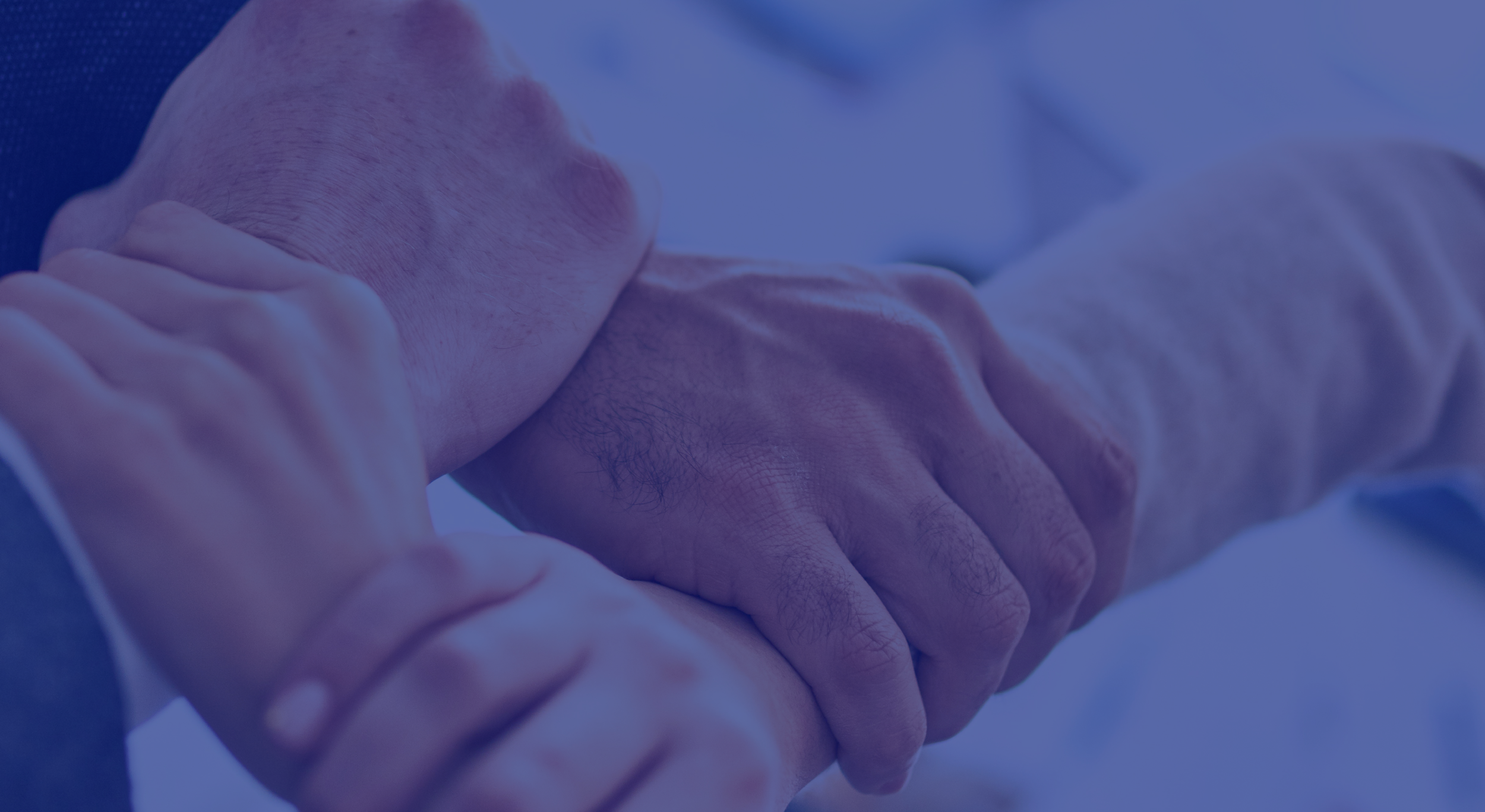 Manos entrelazadas realizando terapia o acompañamiento.