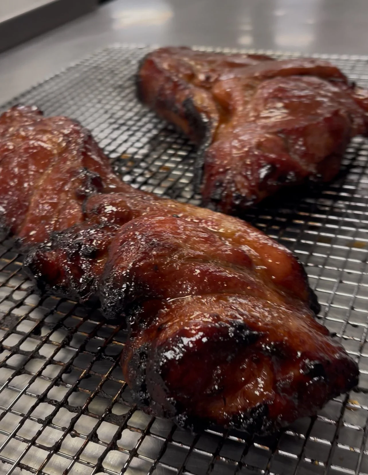 Barbecue pork ribs on a wire rack, glazed with barbecue sauce.