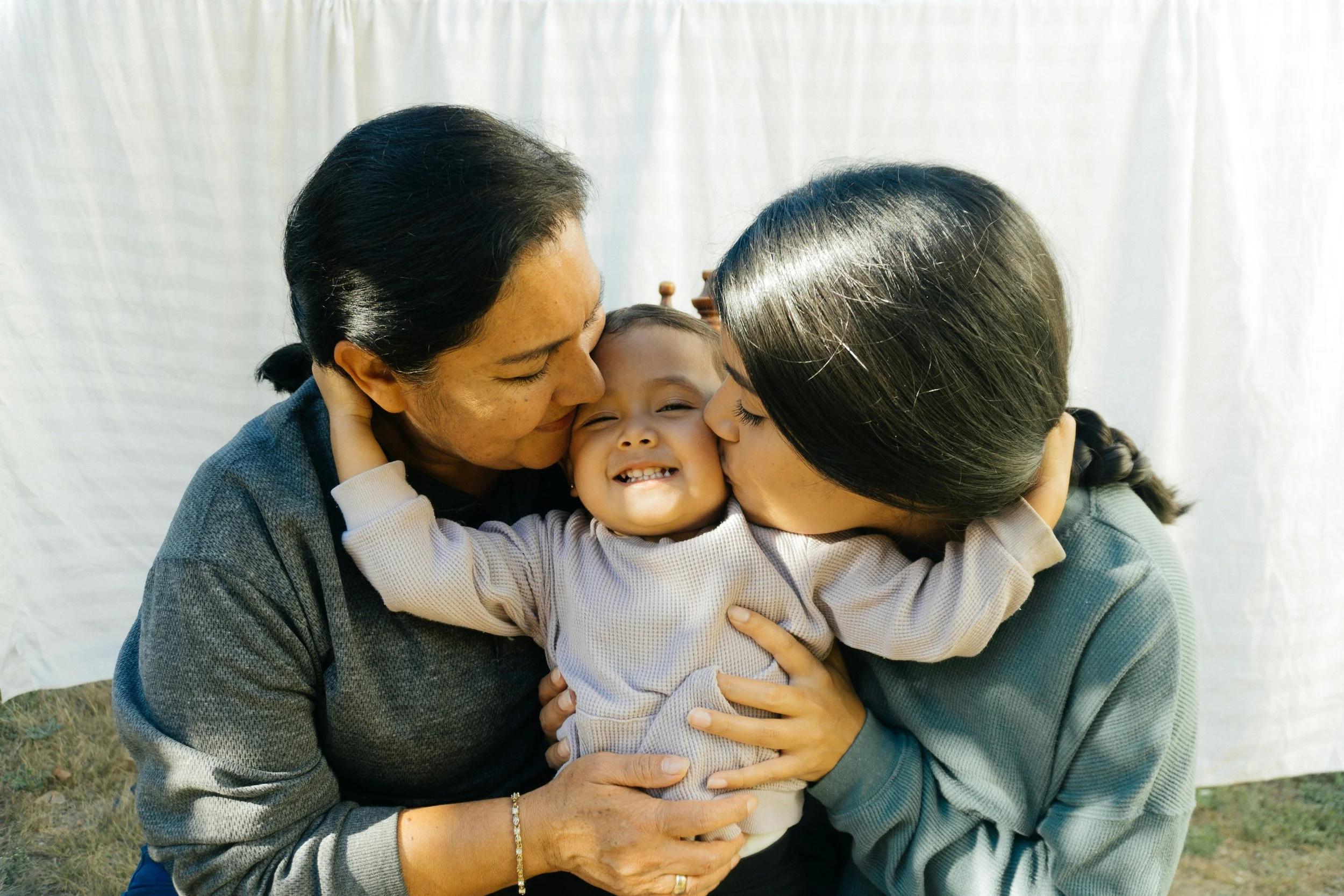 a happy toddler hugs parents