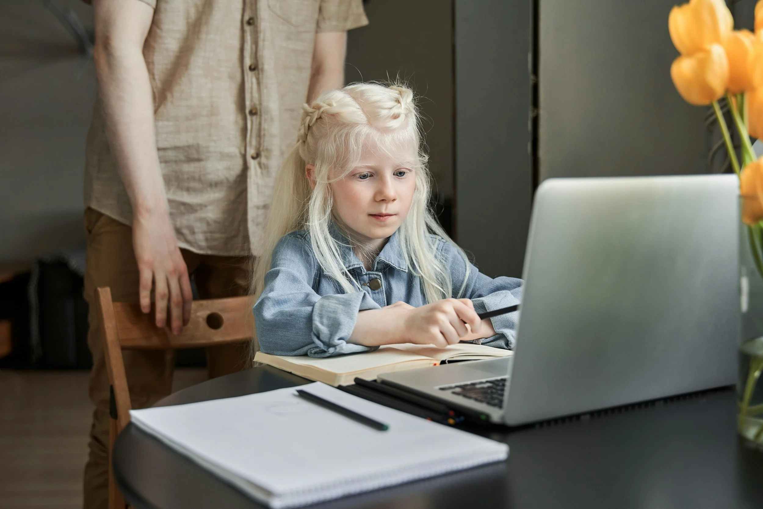 A little girl does homework at a computer