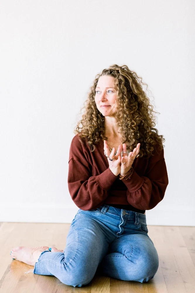 A Woman sitting on the floor with her hands cupped