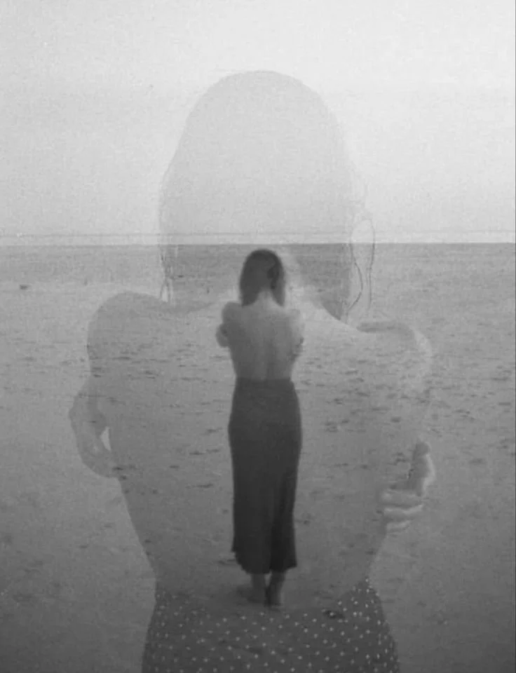 Une image en double exposition montrant une femme et une silhouette d'une personne sur la plage.